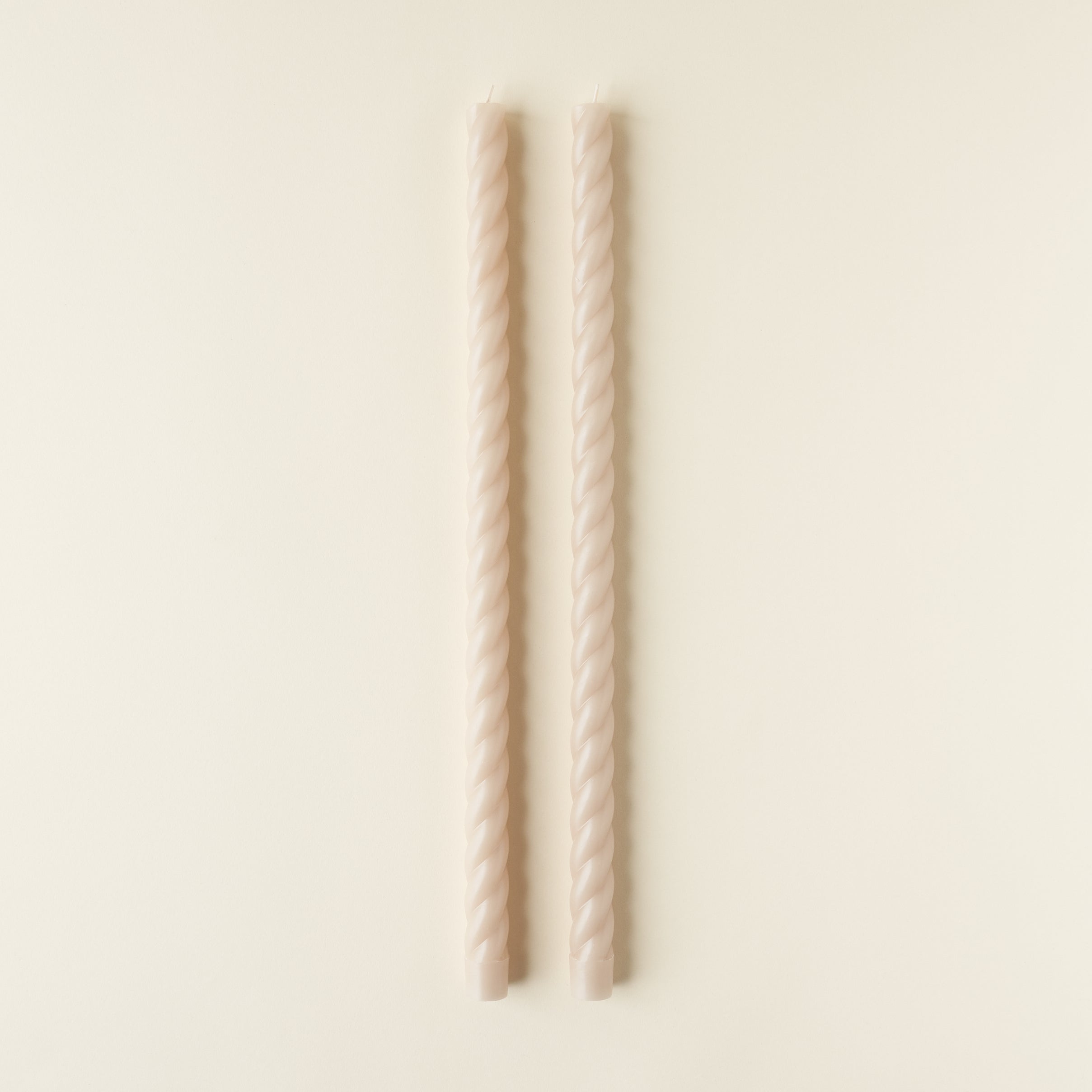 Set of two twisted taper candles in a solid color.