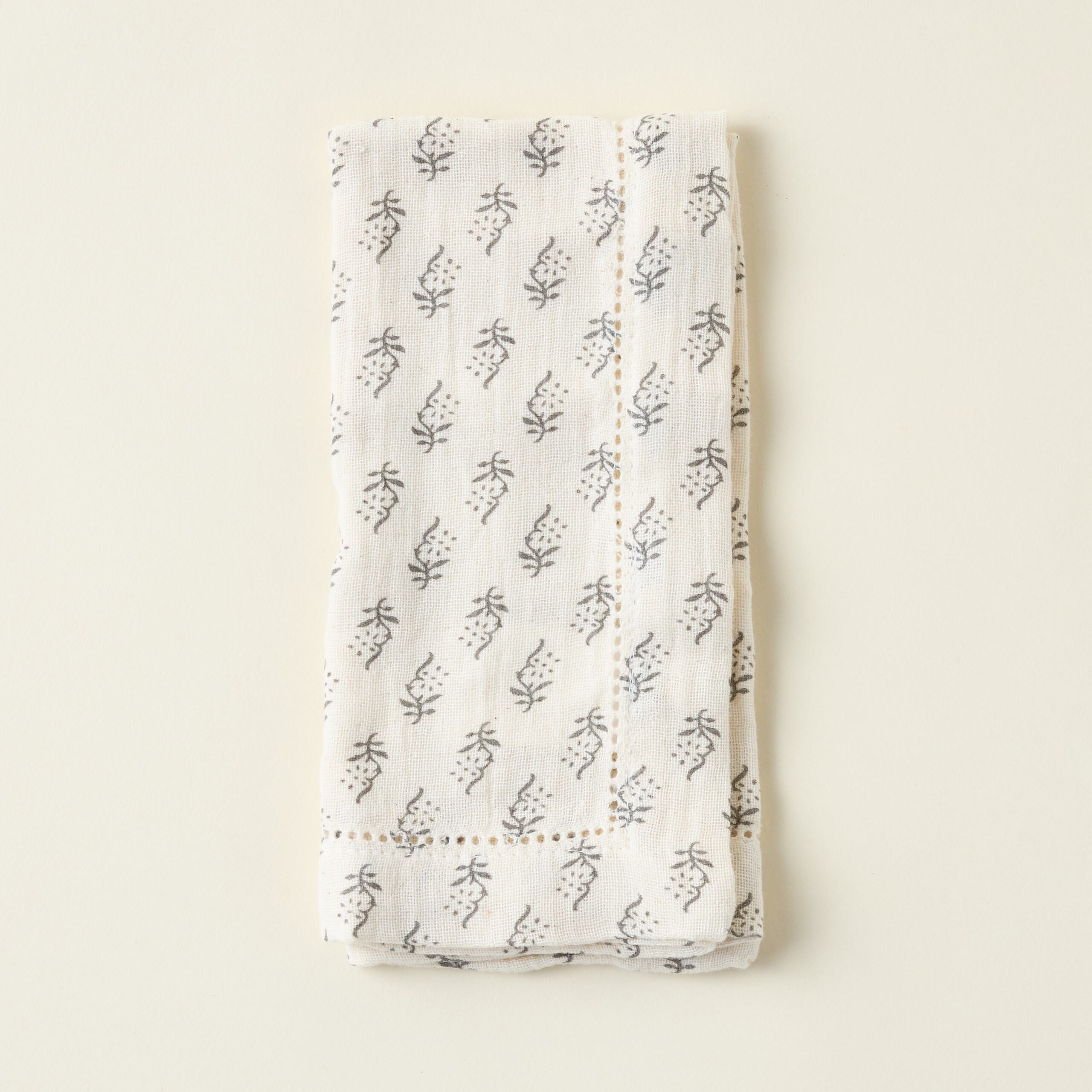 Cream-colored cotton napkins with a charcoal print.