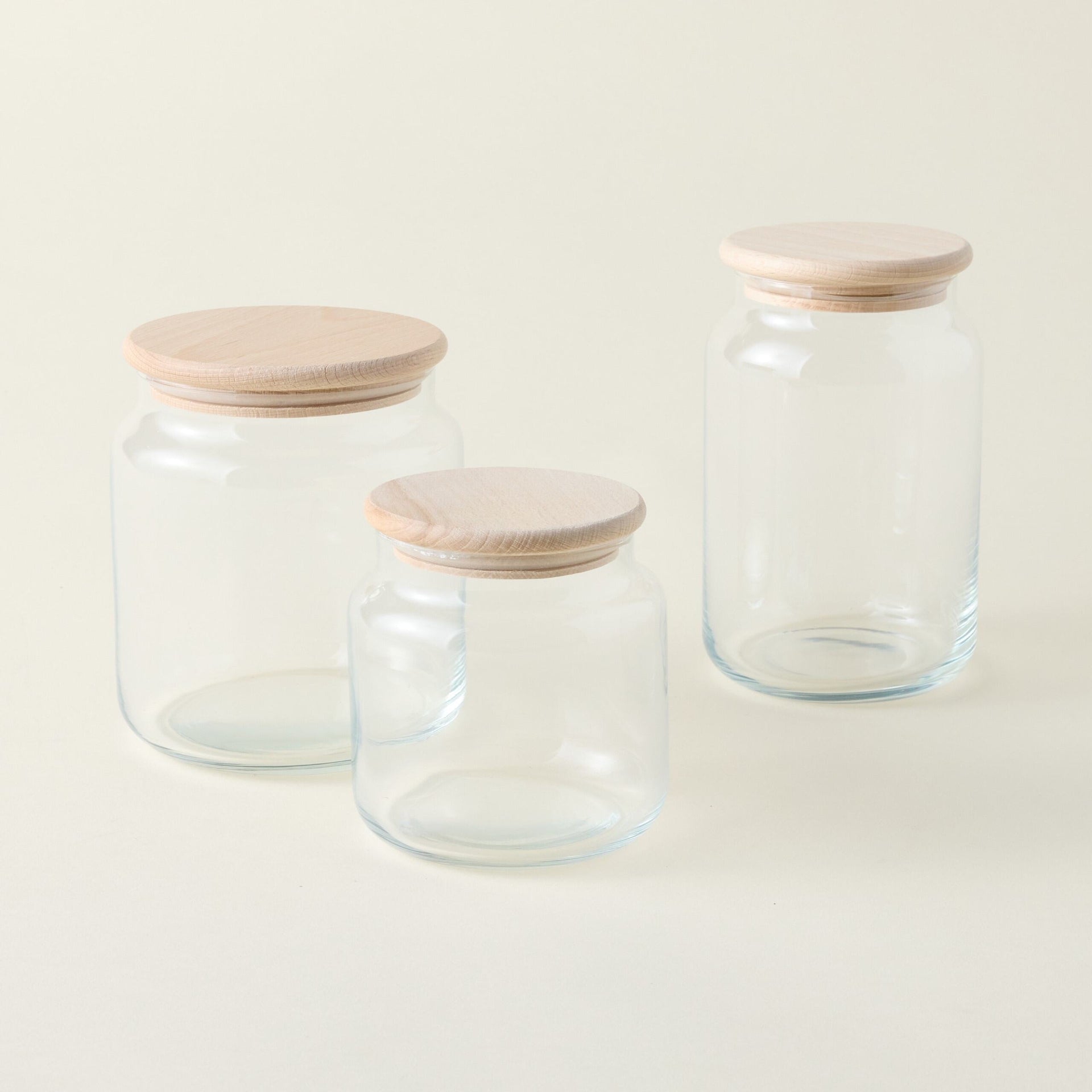 Glass dry goods canister with a wooden lid and a natural, organic aesthetic, styled for a tidy pantry.
