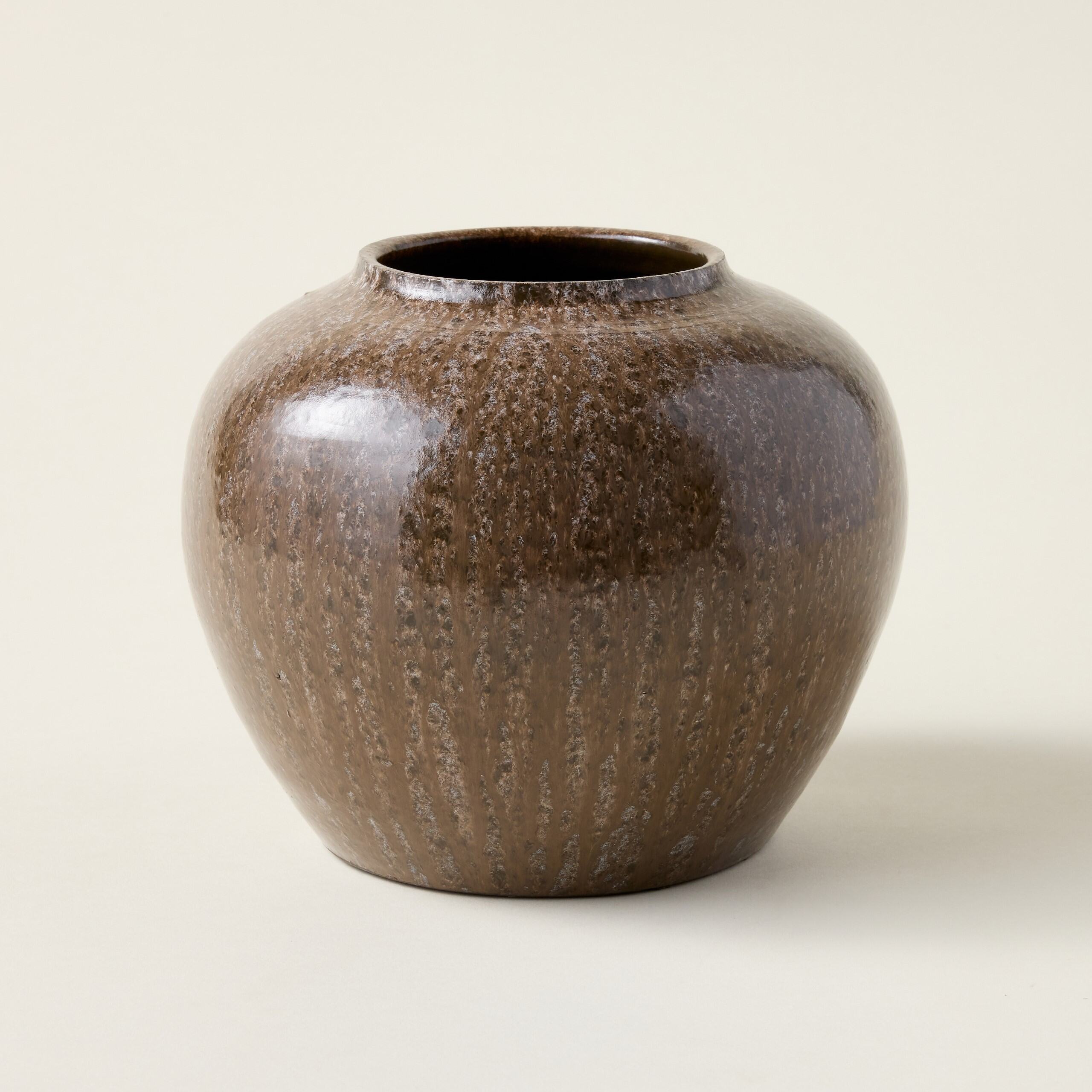 A brown mocha-toned vase with a glossy finish and a curvaceous shape.