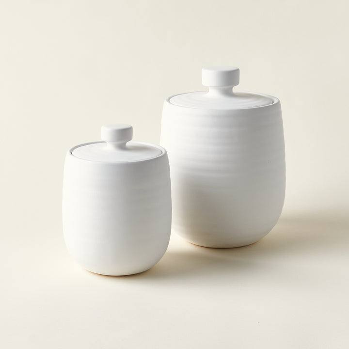 Set of two sleek, white storage canisters.