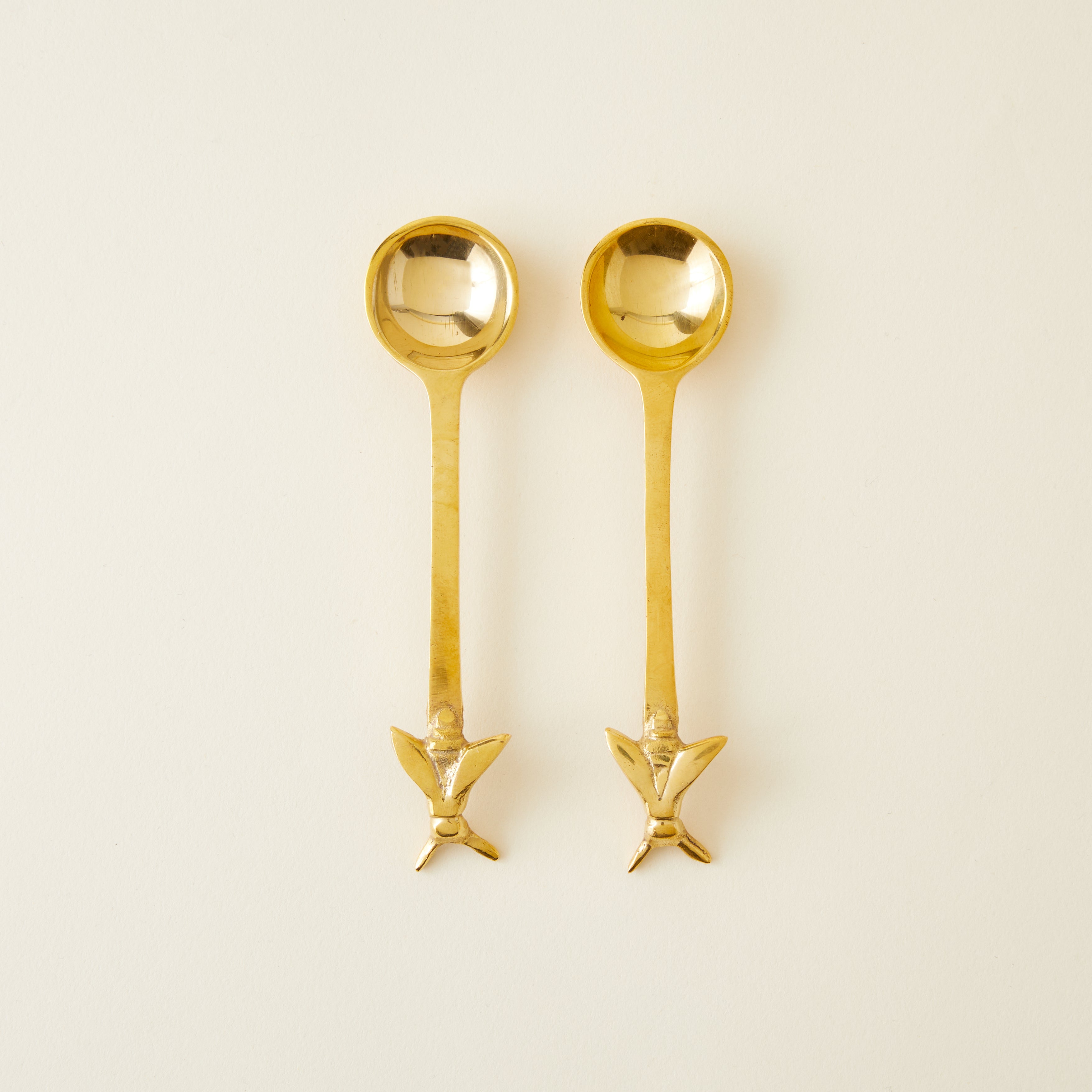Set of two gold bee spoons, 5 inches long, for honey or sugar.