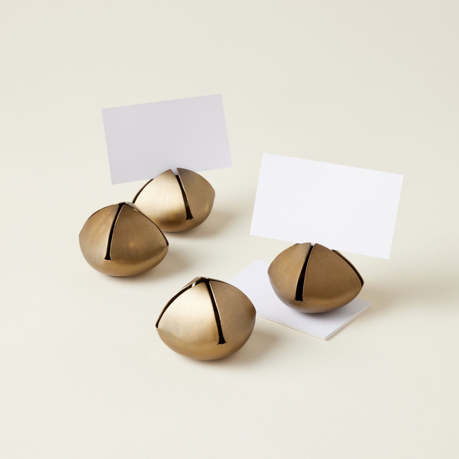A set of four bell-shaped place card holders with an antique iron finish.