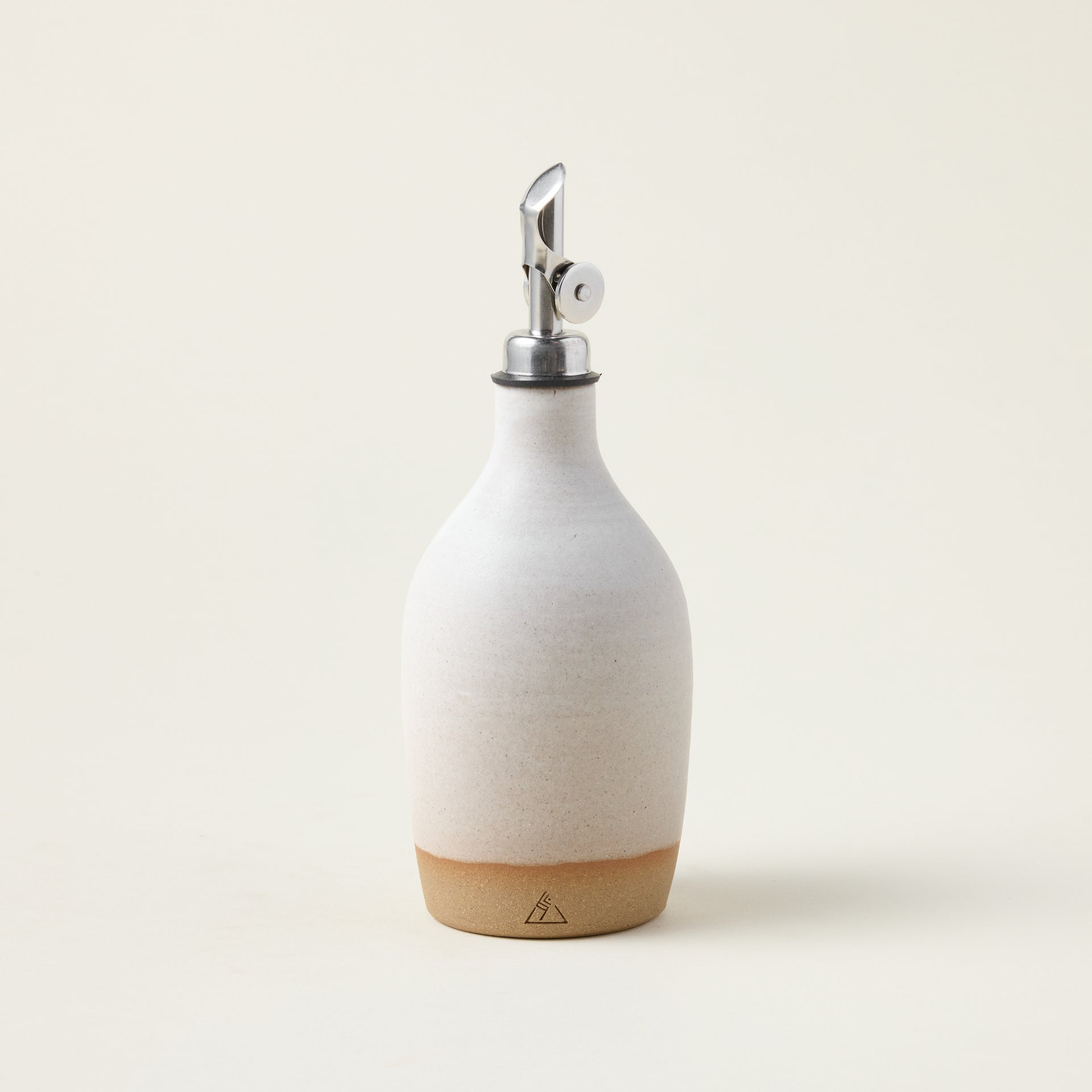 Handcrafted glass oil bottle with a unique shape, a sculptural design, and a minimalist look.