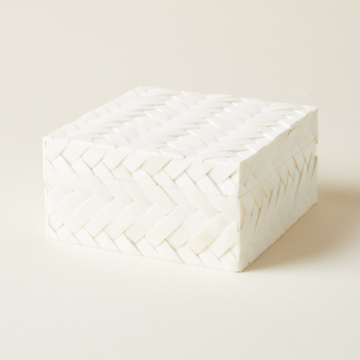 A small decorative storage box with a black and white geometric pattern made from inlaid bone.