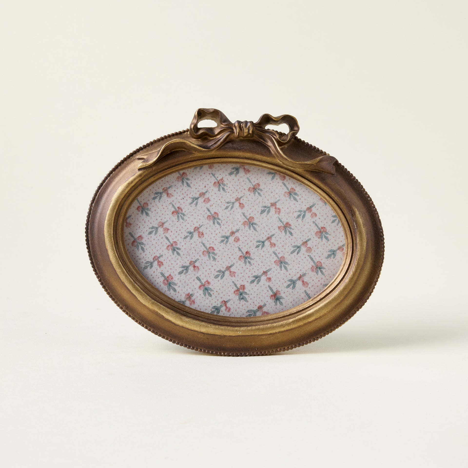 Gold bow photo frame with a sculptural bow design and an elegant, vintage-inspired finish.