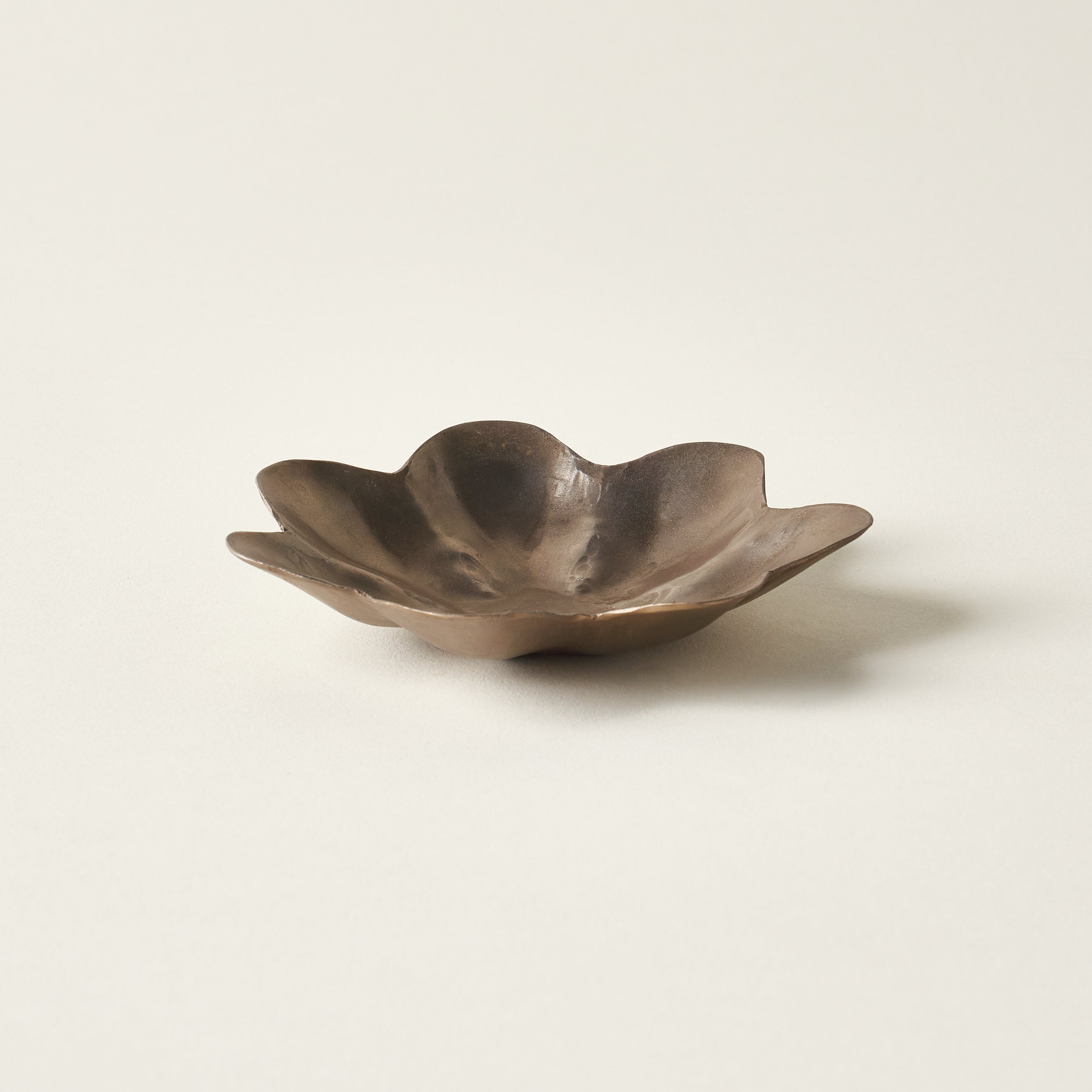 Hand-forged brass dish in the shape of a flower.