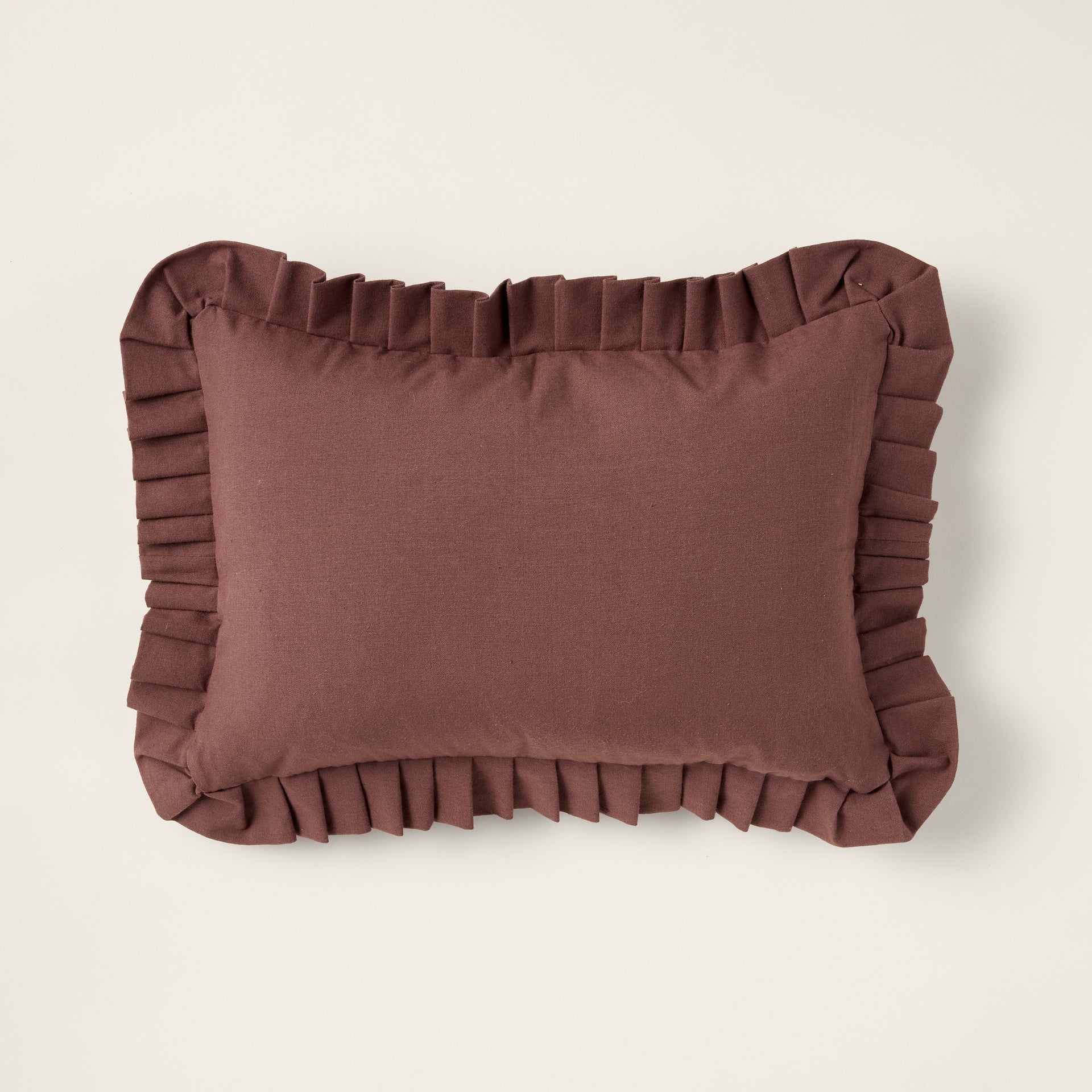 Handcrafted brown ruffle lumbar pillow with a ruffled edge and a rich, earthy color.