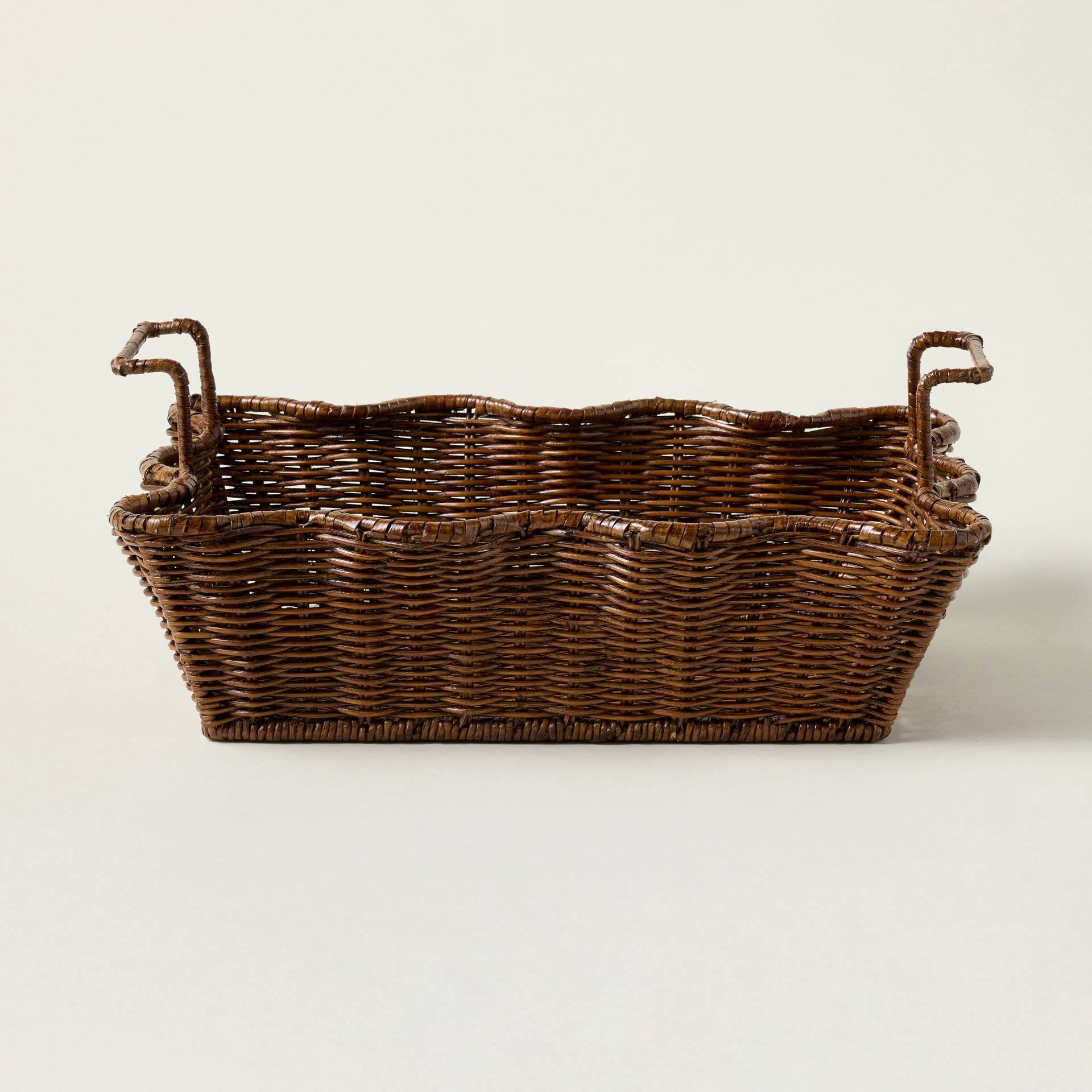 Handcrafted brown rattan tray with an elegant scalloped design and metal wire frame.