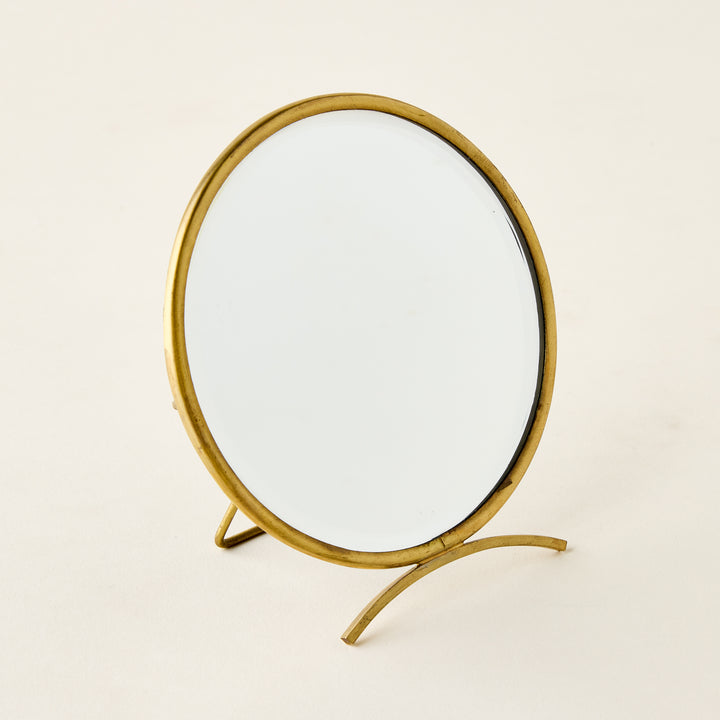 Vintage-inspired brass folding mirror with a round shape and a warm antique finish.