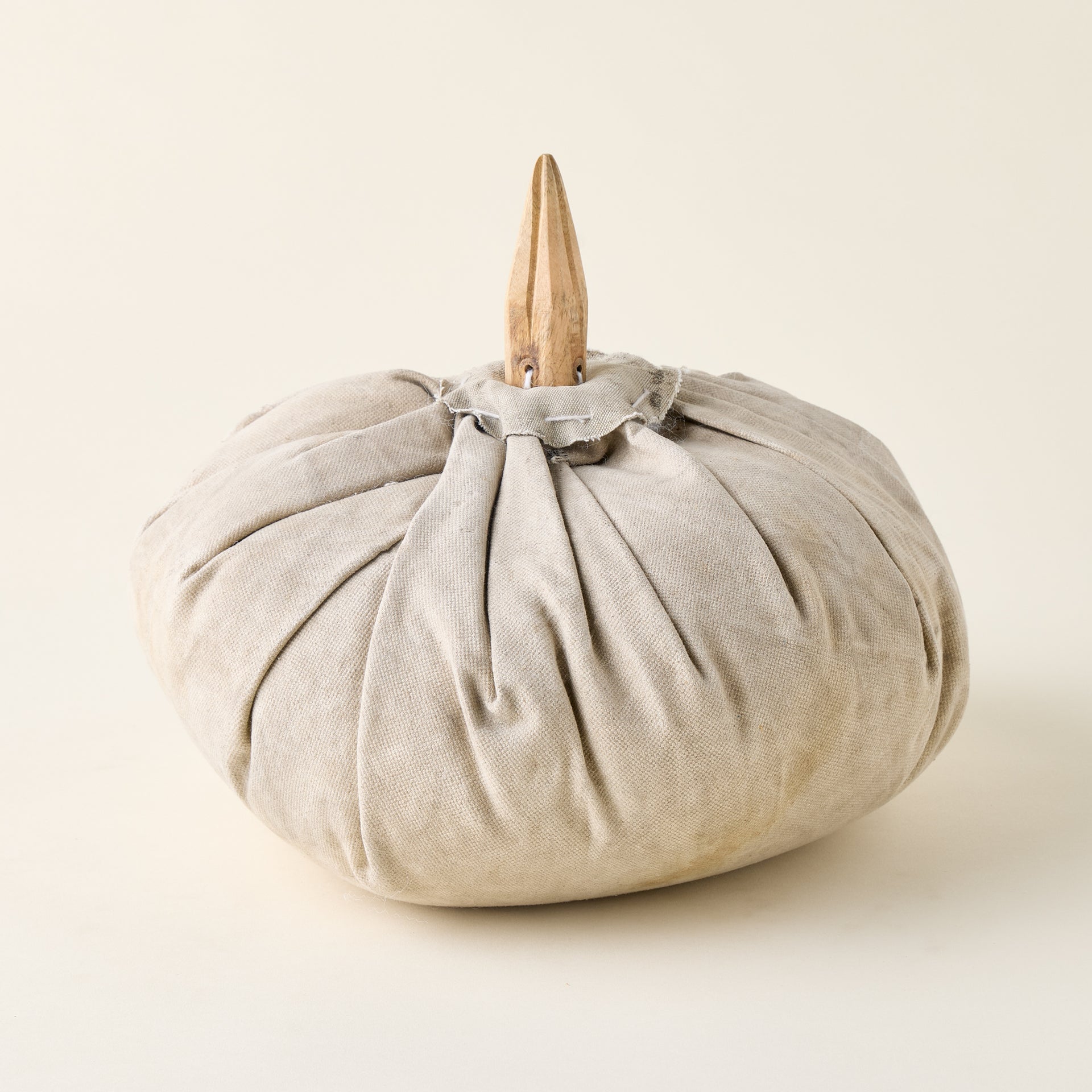 Vintage-inspired canvas pumpkin with a mango wood stem, styled as a unique piece of fall decor.