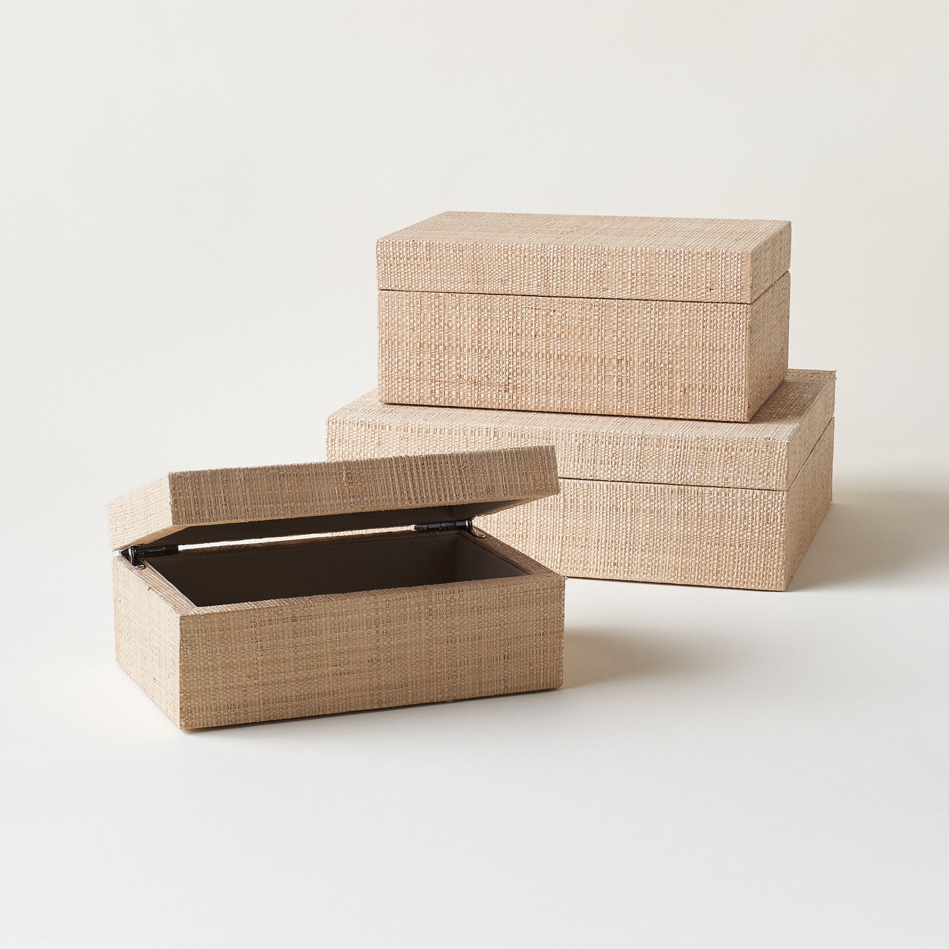 A set of three hinged storage boxes in varying sizes, each covered in a woven grasscloth texture.