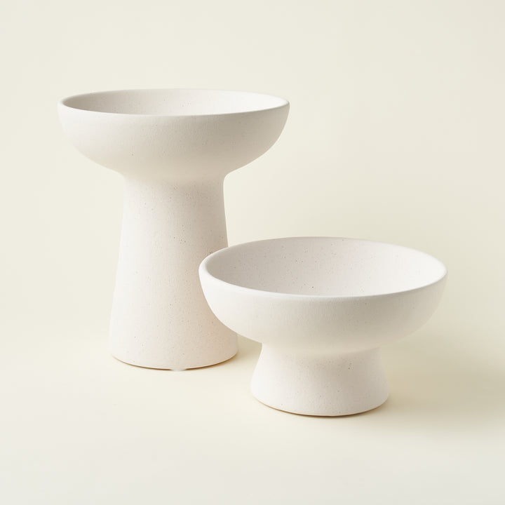 A set of two ceramic compotes in two different sizes, styled together to show their varied heights.