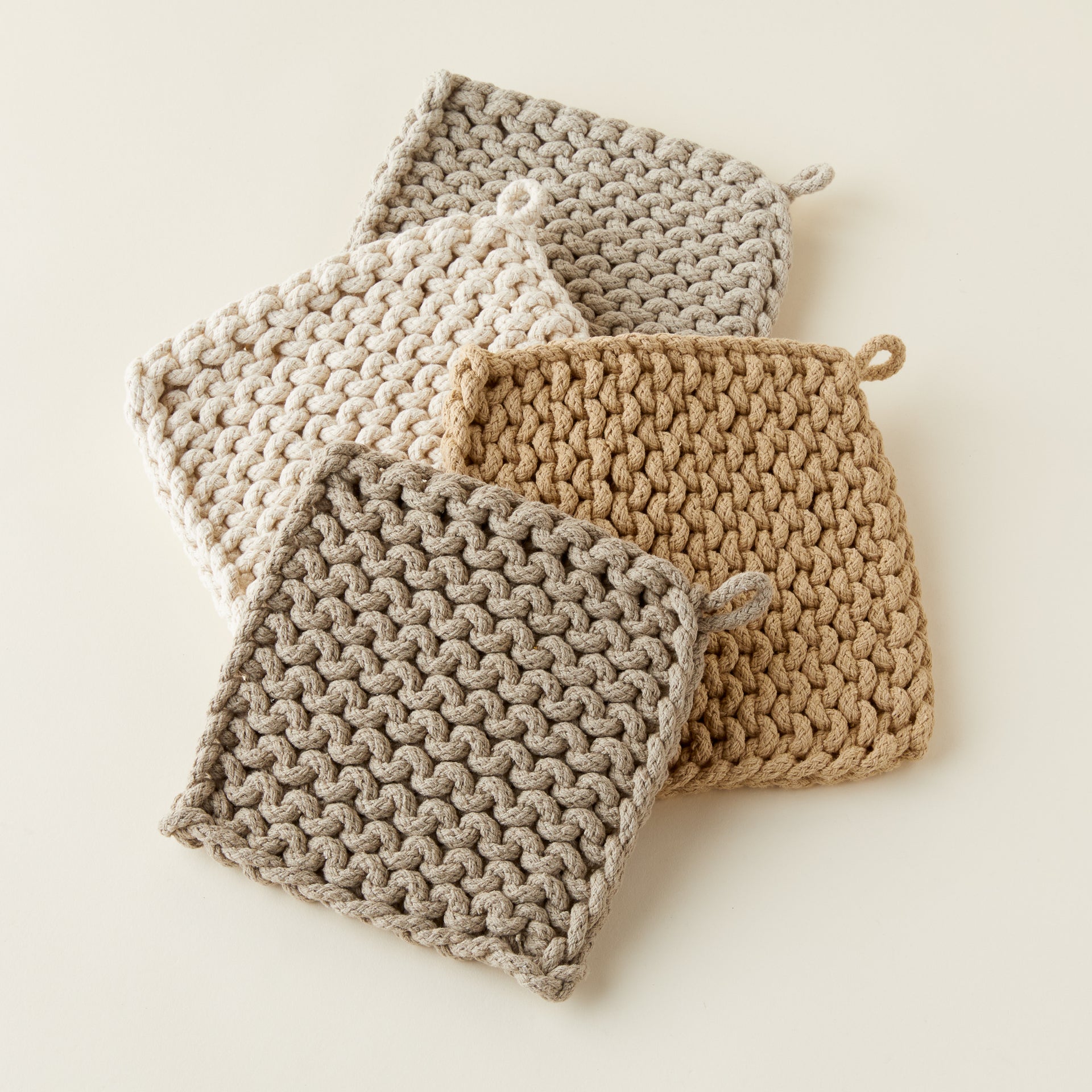 Handcrafted chunky crocheted pot holder with a unique, artisanal texture in a neutral color.