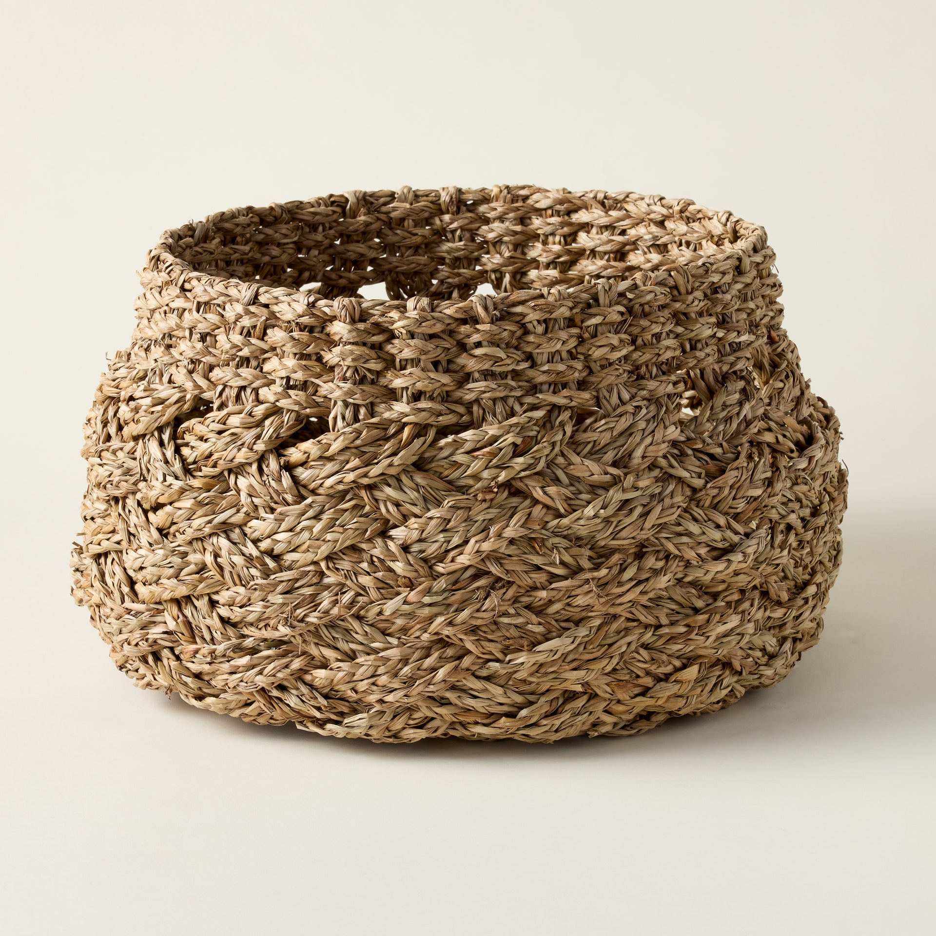 Set of three handwoven seagrass baskets with a cross weave design for home storage.