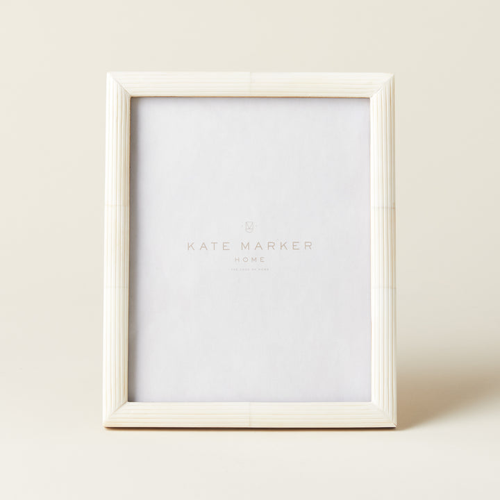 A decorative 8x10 photo frame with an intricate etched pattern on its white bone surface.