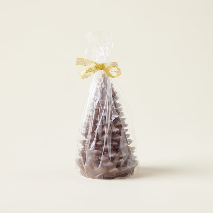 A decorative candle shaped like an evergreen tree with a smooth, matte finish and subtle gold tips.