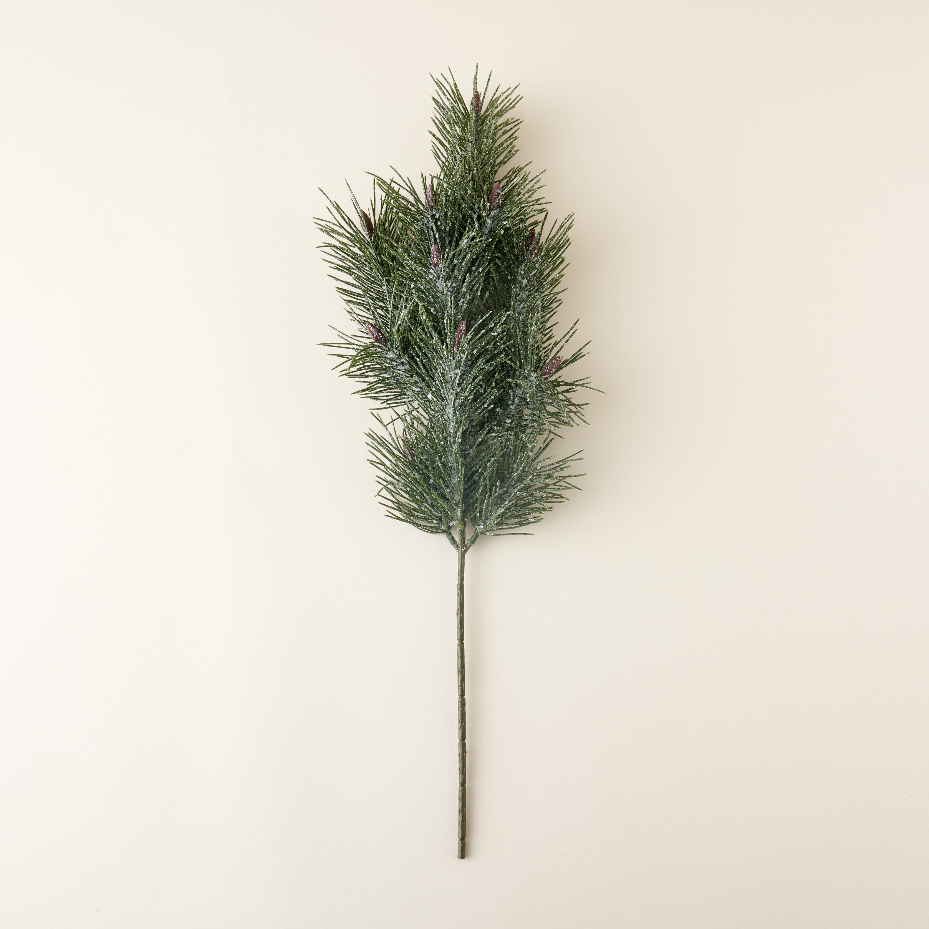A faux pine branch with a white, frost-like finish.