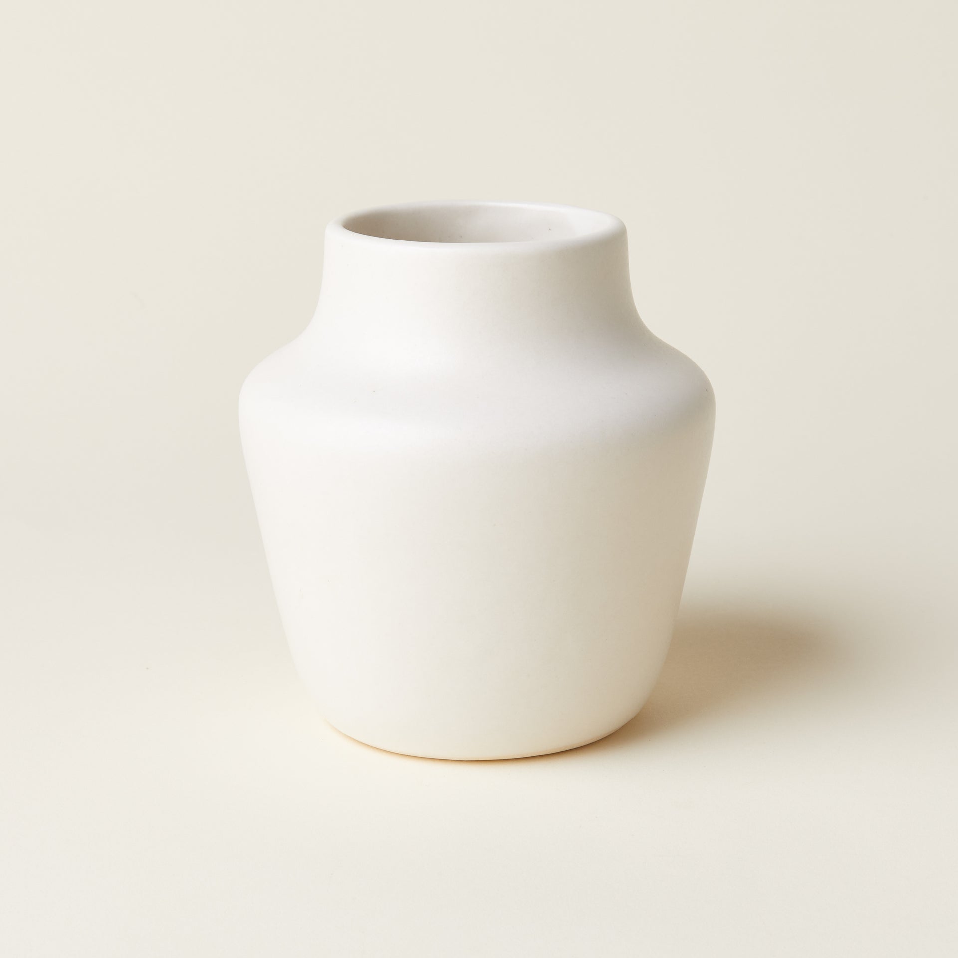 A decorative vase with a modern, asymmetrical design and a natural green color.