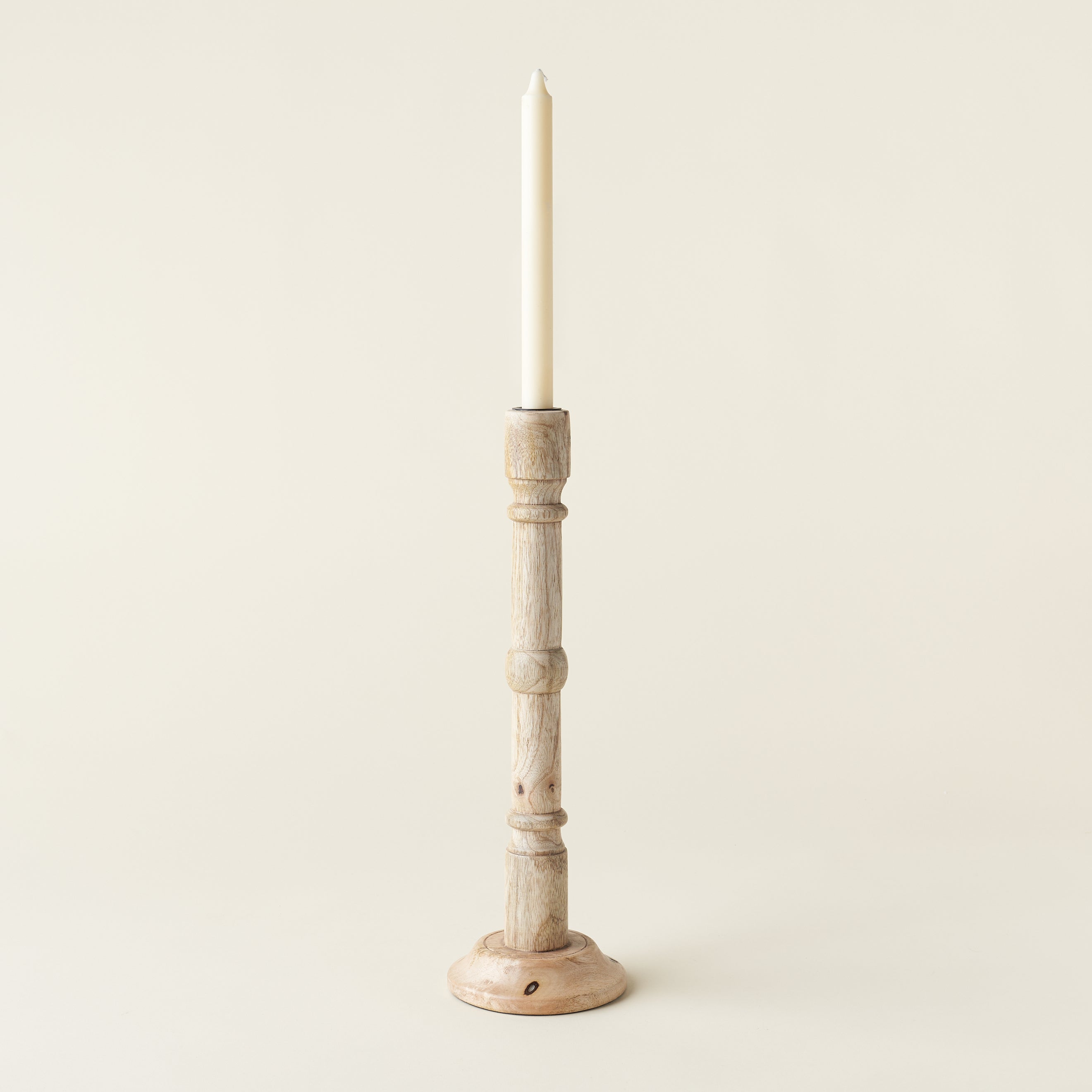 A hand-carved mango wood taper holder.