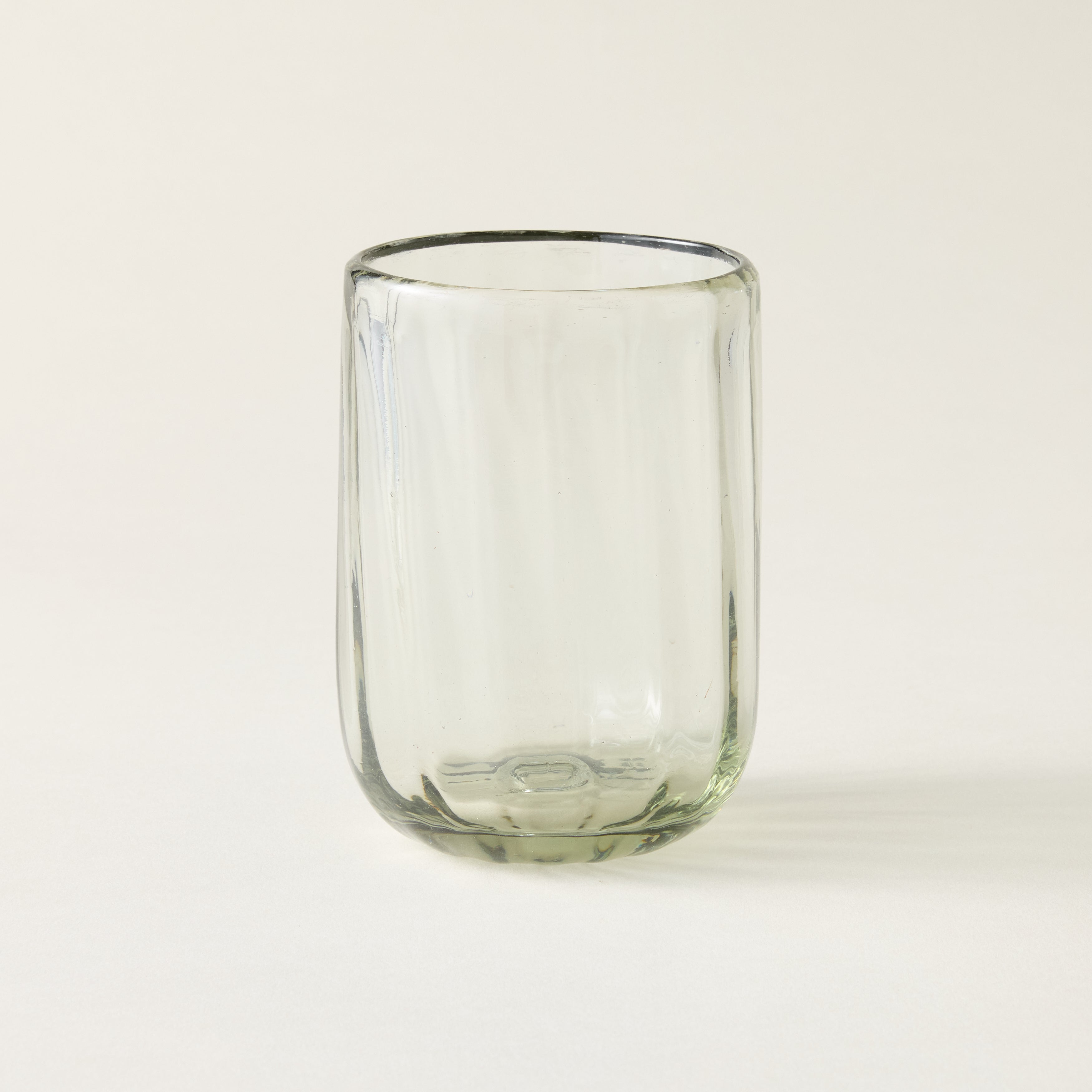 Handblown fluted tumbler crafted from recycled glass with air bubbles and an artisanal feel.