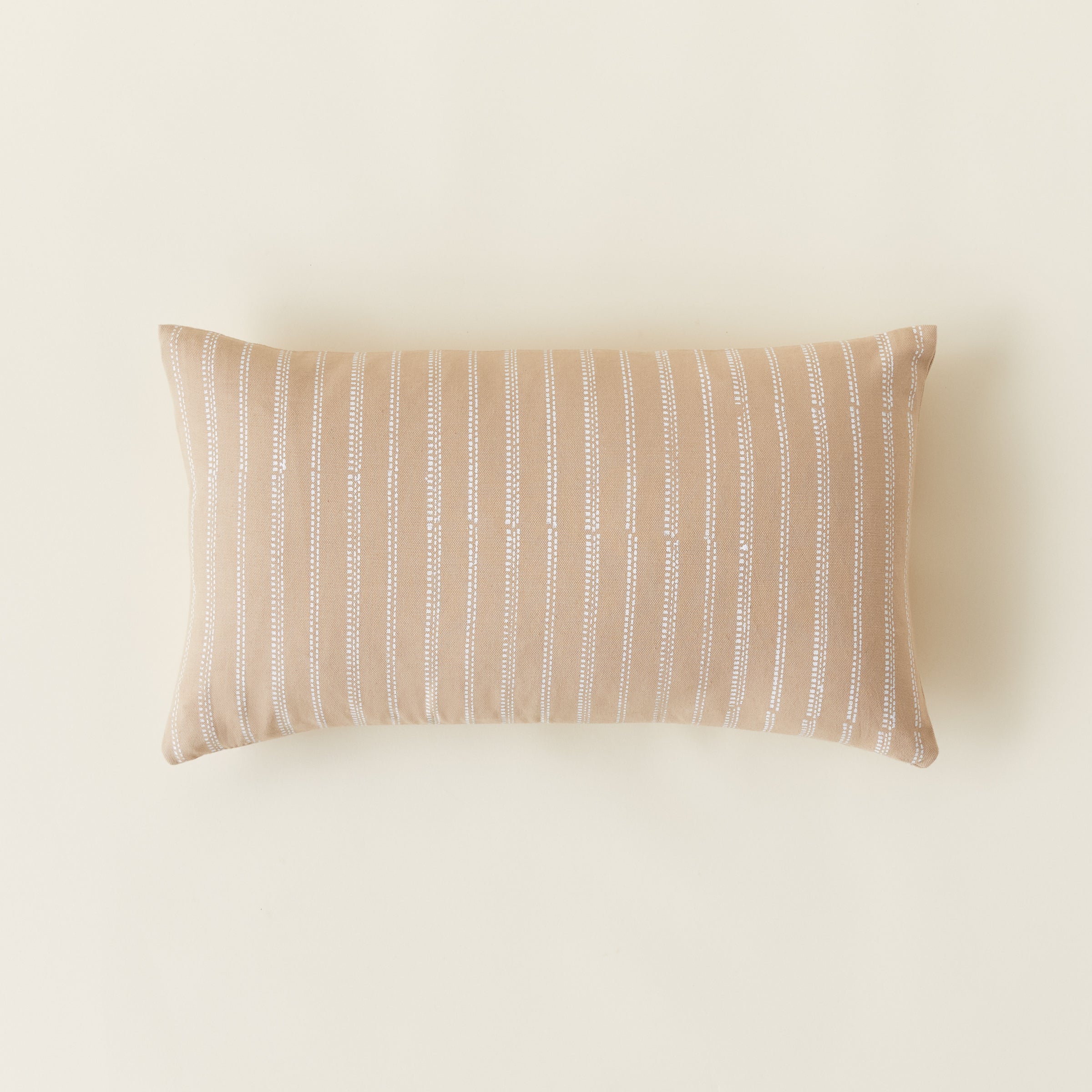 A handwoven lumbar pillow cover with a broken stripe pattern in soft, textured colors.