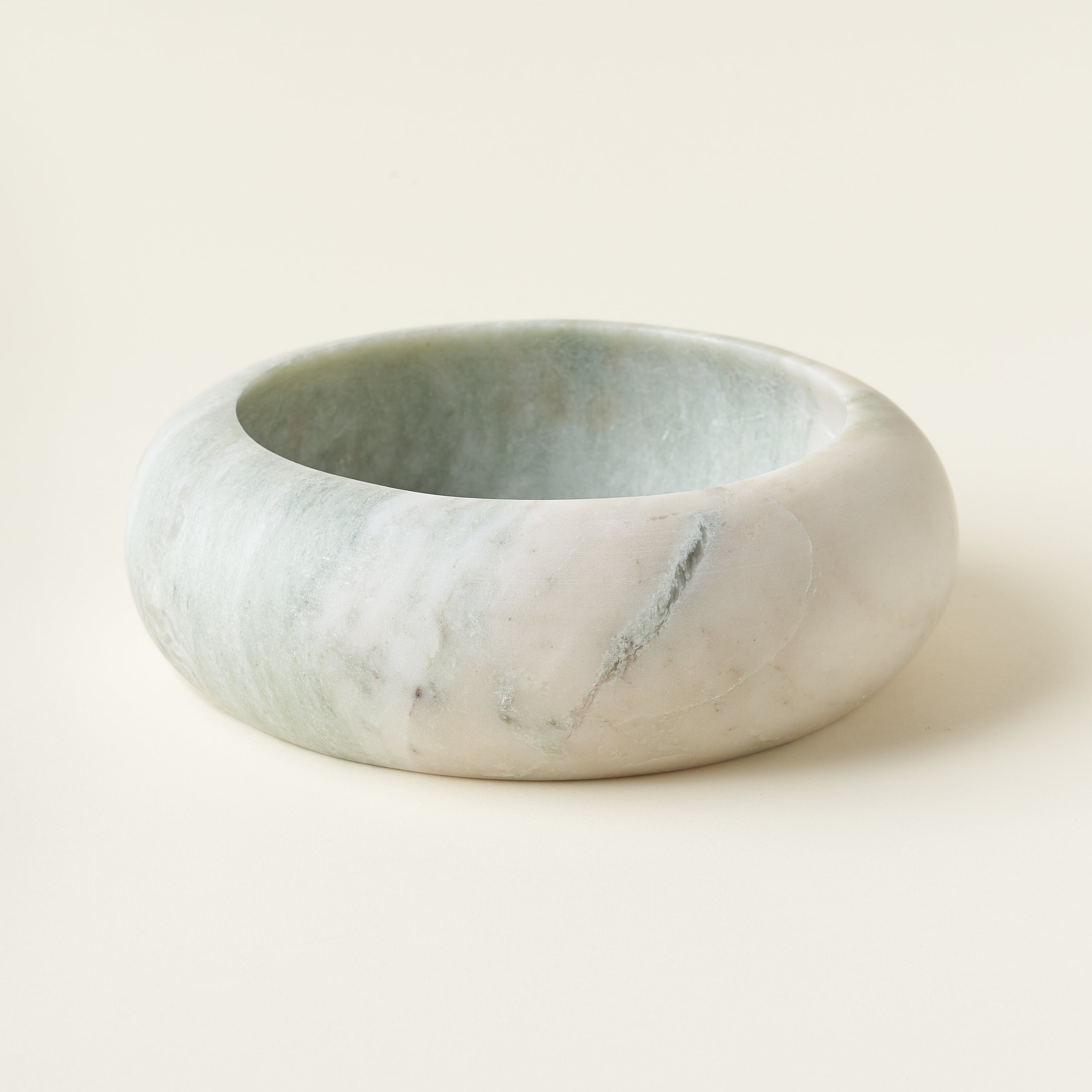 A decorative bowl made from genuine onyx with natural veining, sitting on a flat surface.