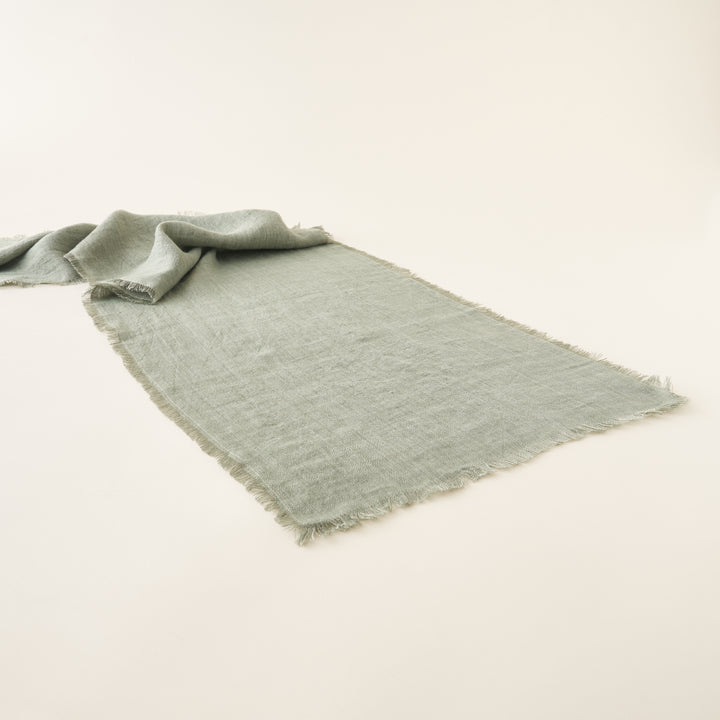 Laurel linen table runner in sage green with eyelash fringe.