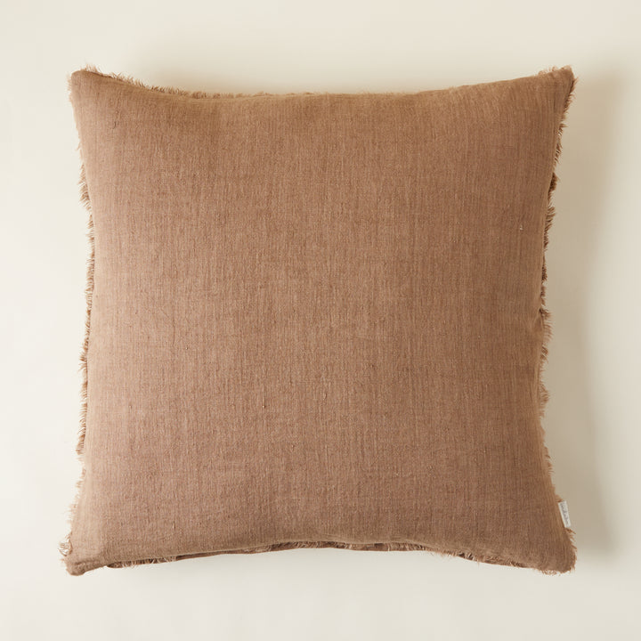 Hazelnut linen pillow with a delicate frayed edge and a soft, stone-washed texture.