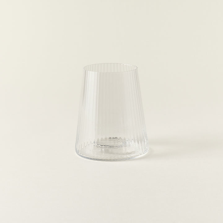 A clear drinking glass with a delicate, fluted texture and a smooth rim.