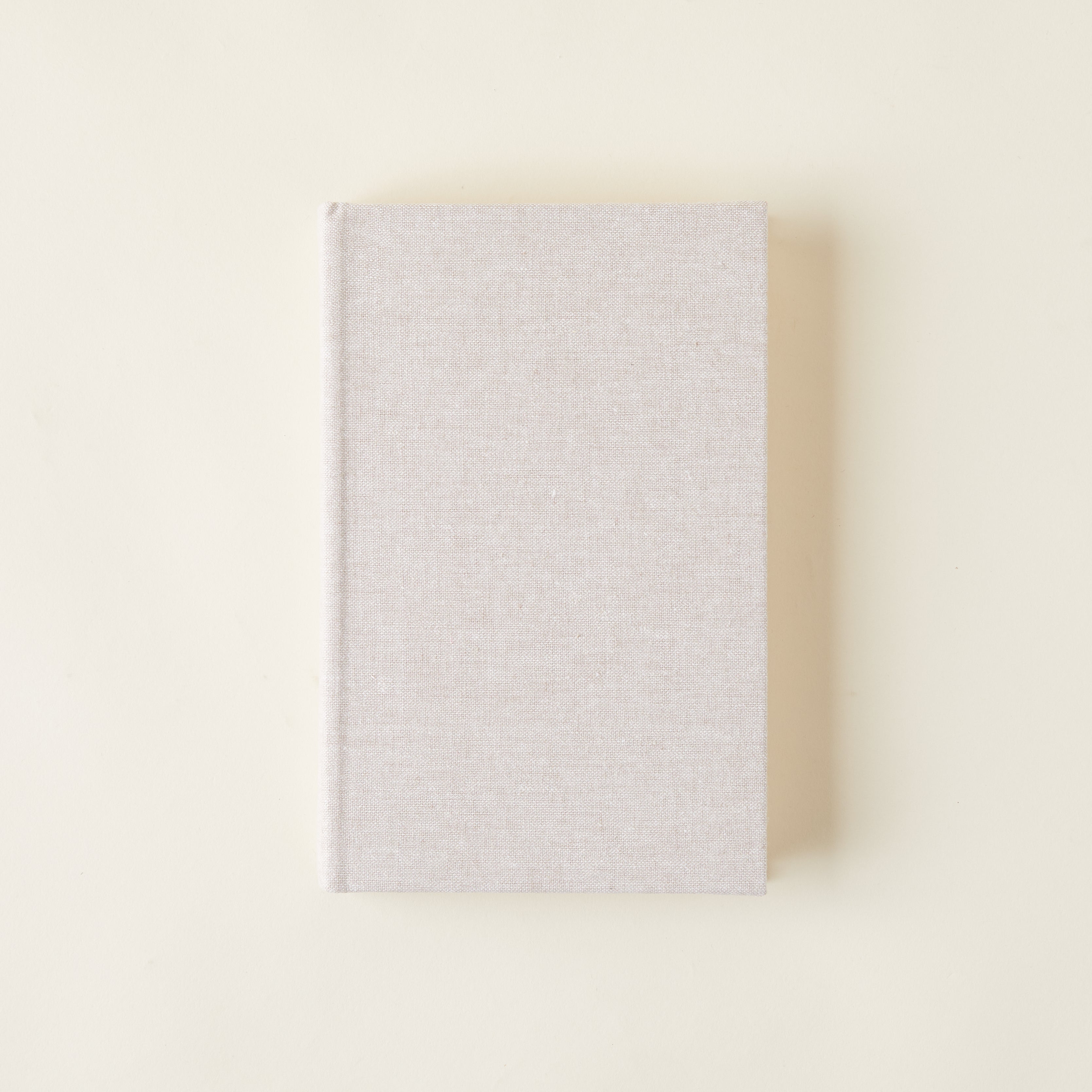 Linen-covered books for decorative styling on a bookshelf.