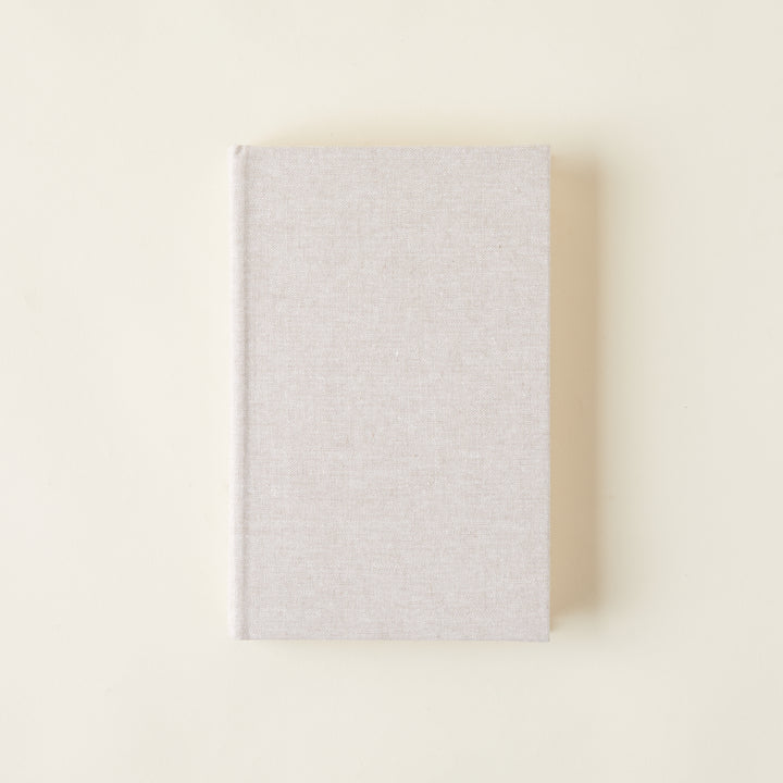 Linen-covered books for decorative styling on a bookshelf.