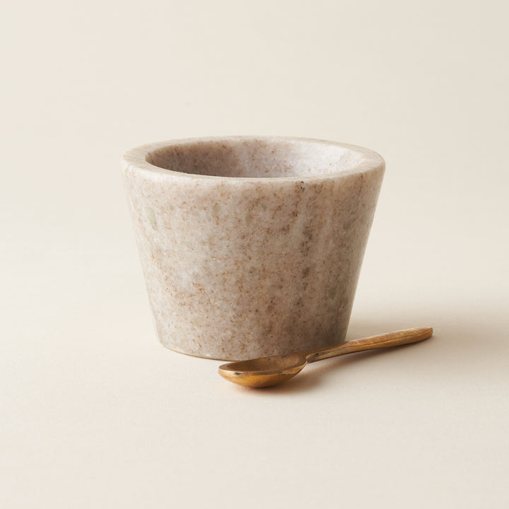 Small marble bowl with a brass serving spoon.