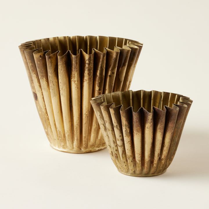 Set of two brass metal planters with a fluted design.
