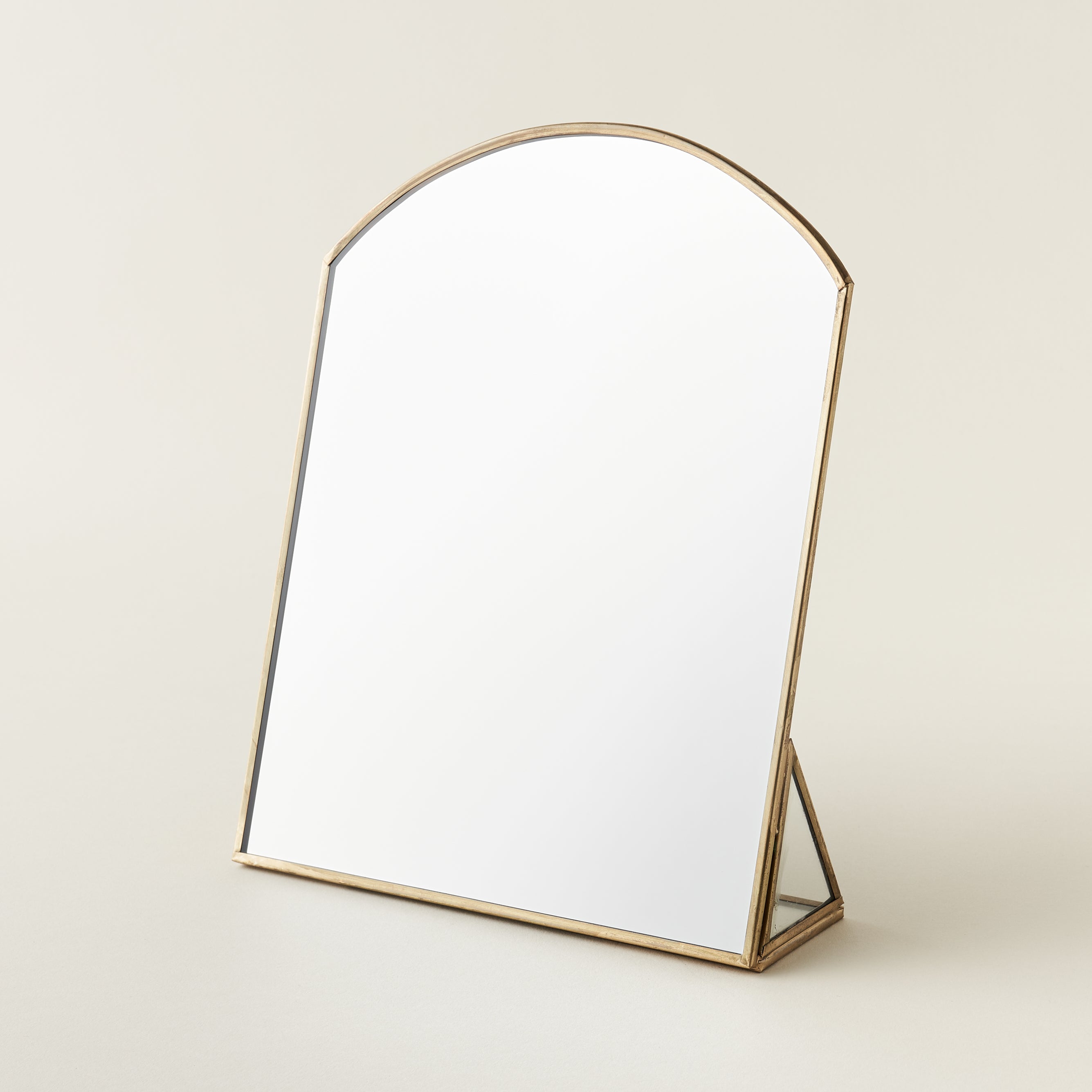 Metal framed standing mirror with a brass finish.