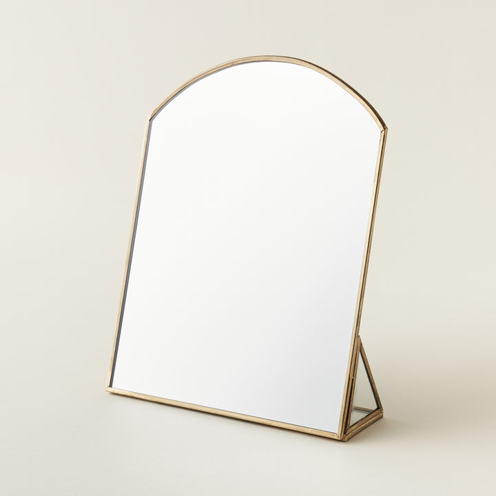 Metal framed standing mirror with a brass finish.