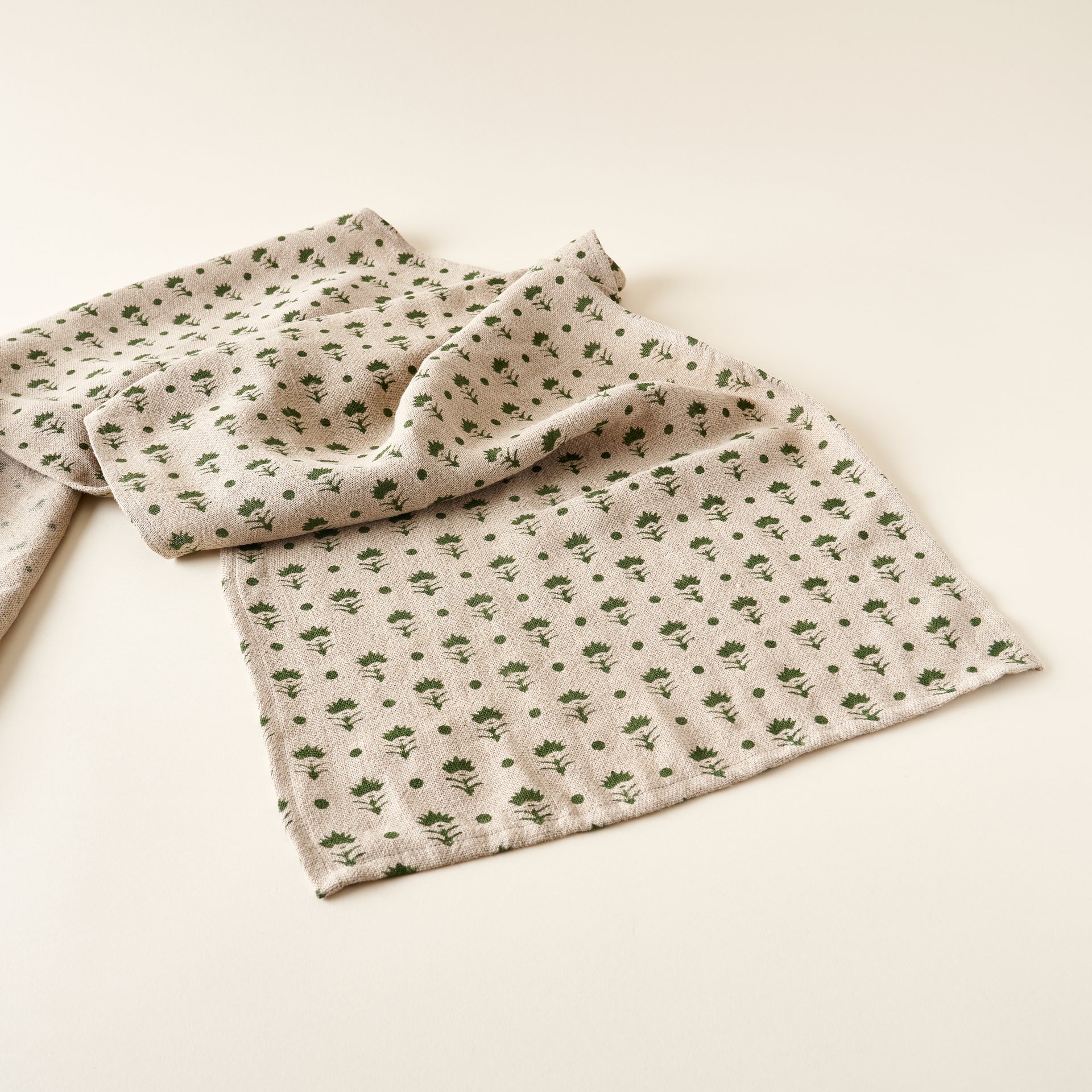 Olivia linen table runner, hand-block printed with a floral design in olive.