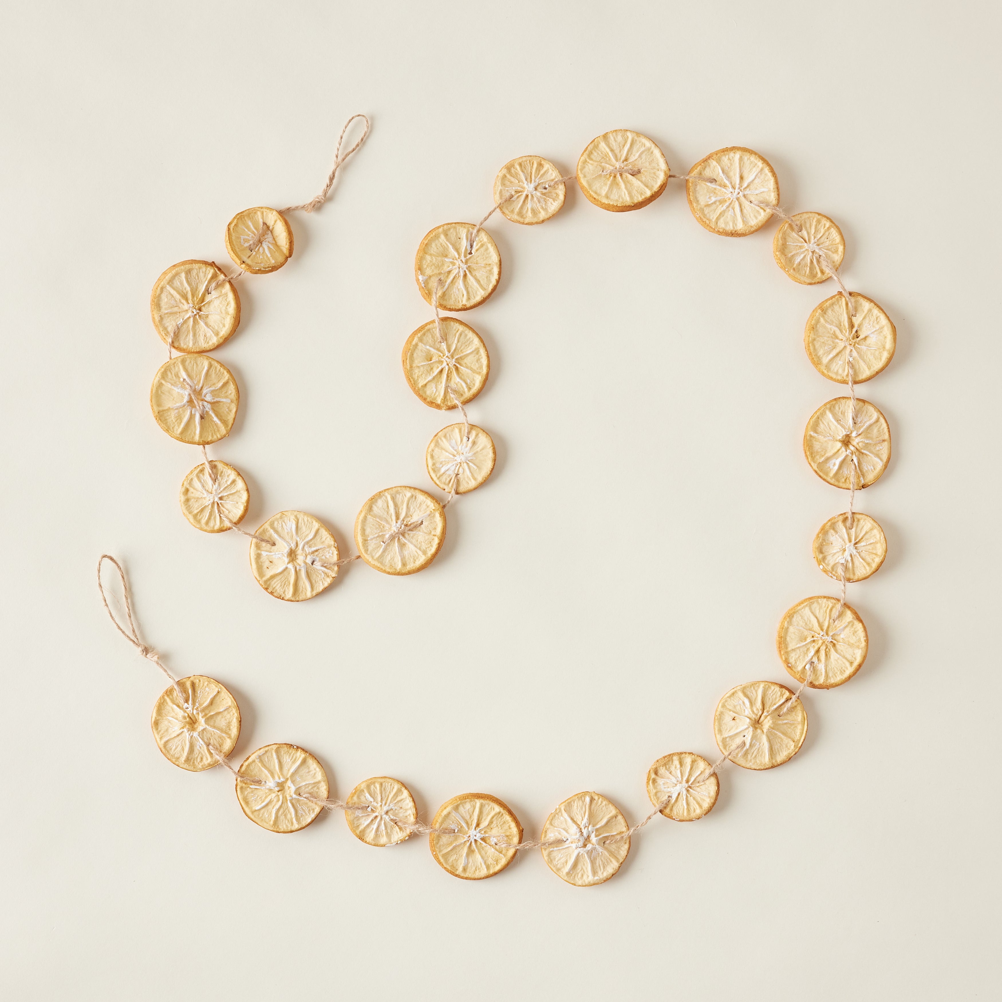 A faux garland featuring realistic-looking orange slices made from plastic and foam.