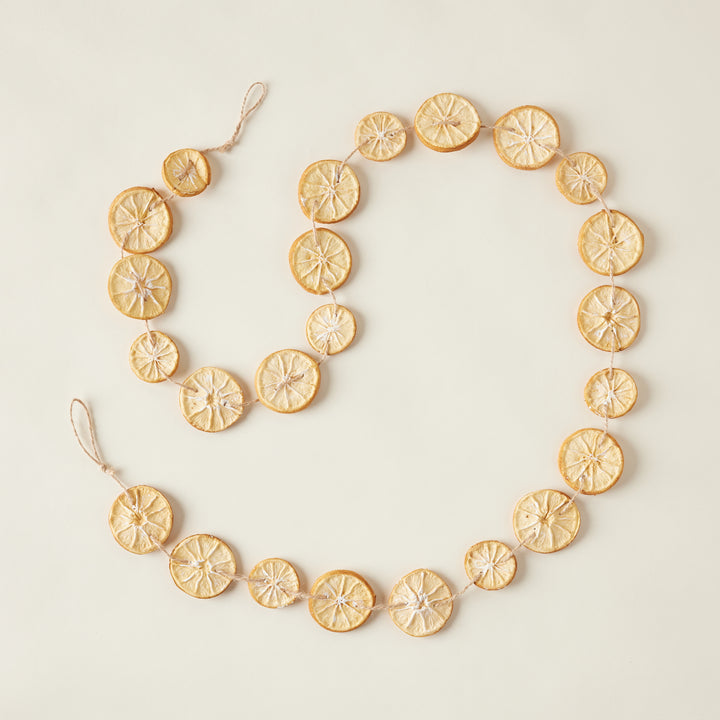 A faux garland featuring realistic-looking orange slices made from plastic and foam.