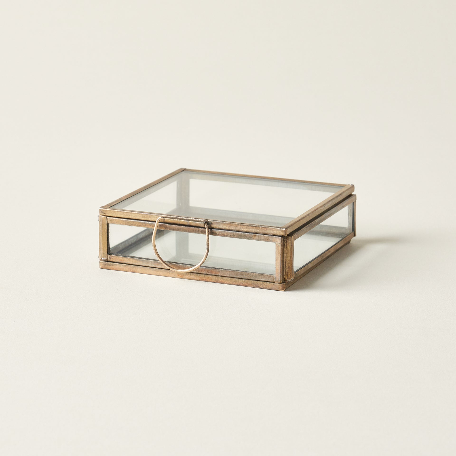 Petite brass display box with a timeless design and leaded glass panels, styled as a refined jewelry case.