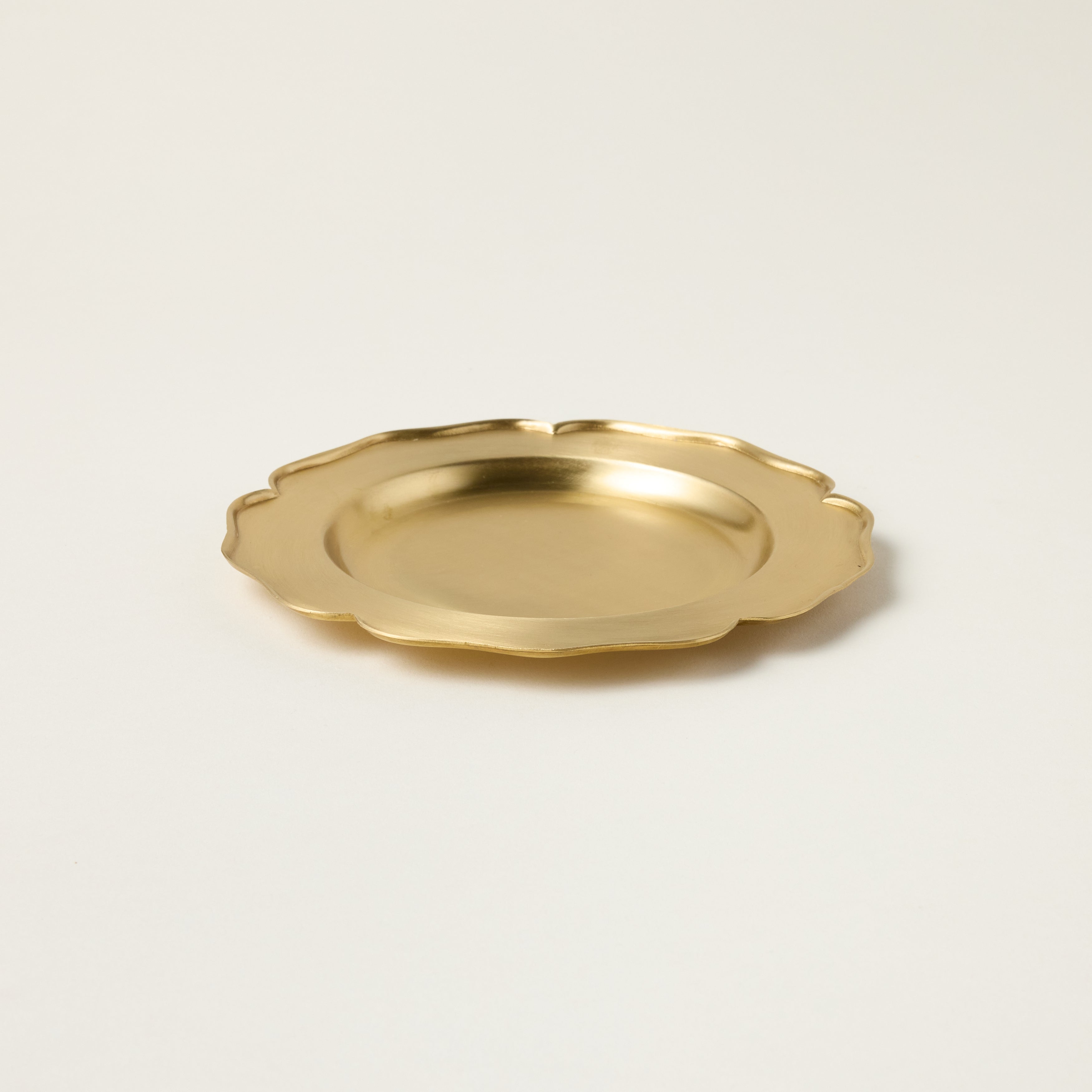 Vintage-inspired petite brass tray with a patina finish, used as a decorative catchall for jewelry.