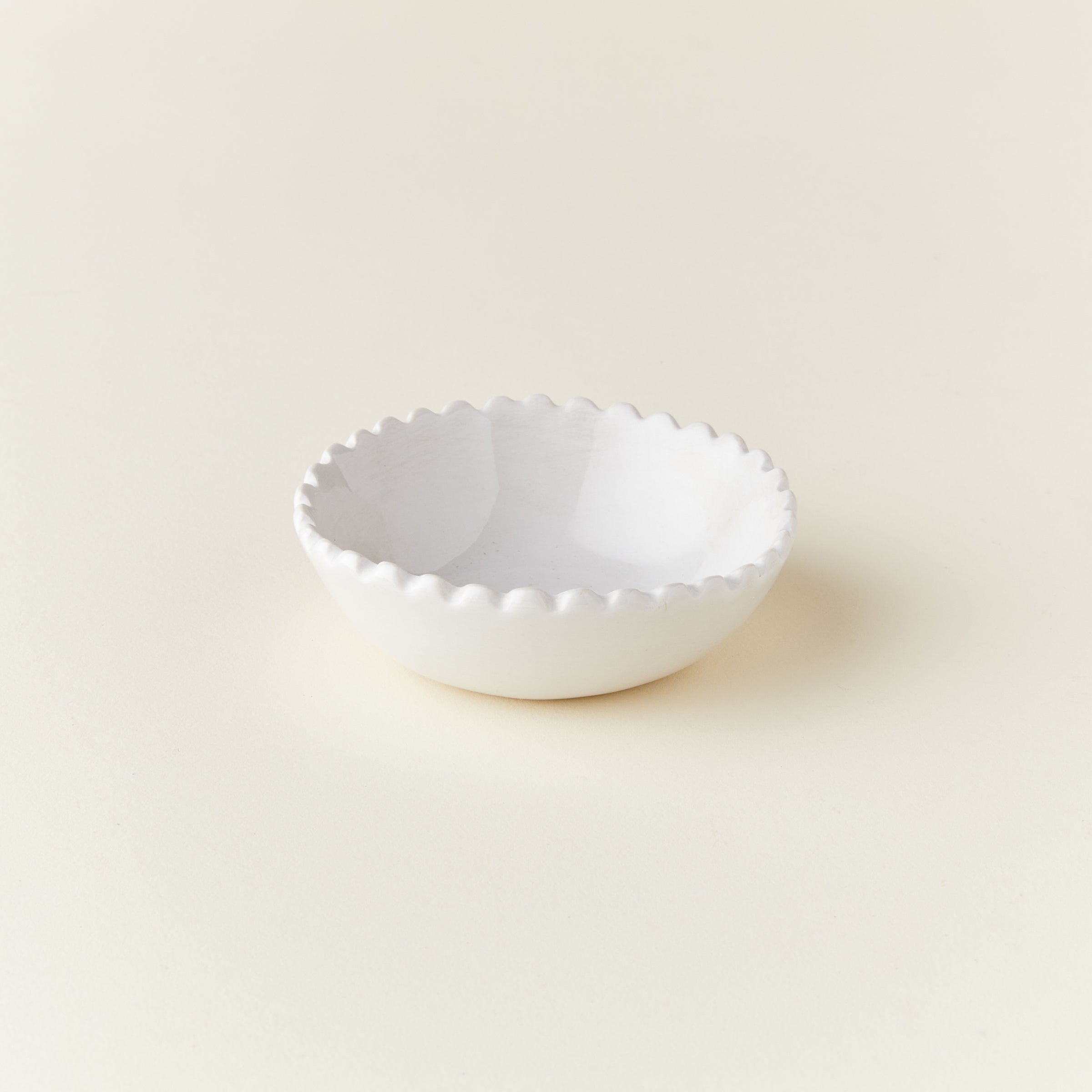 A small decorative bowl with a ruffled, scalloped edge.