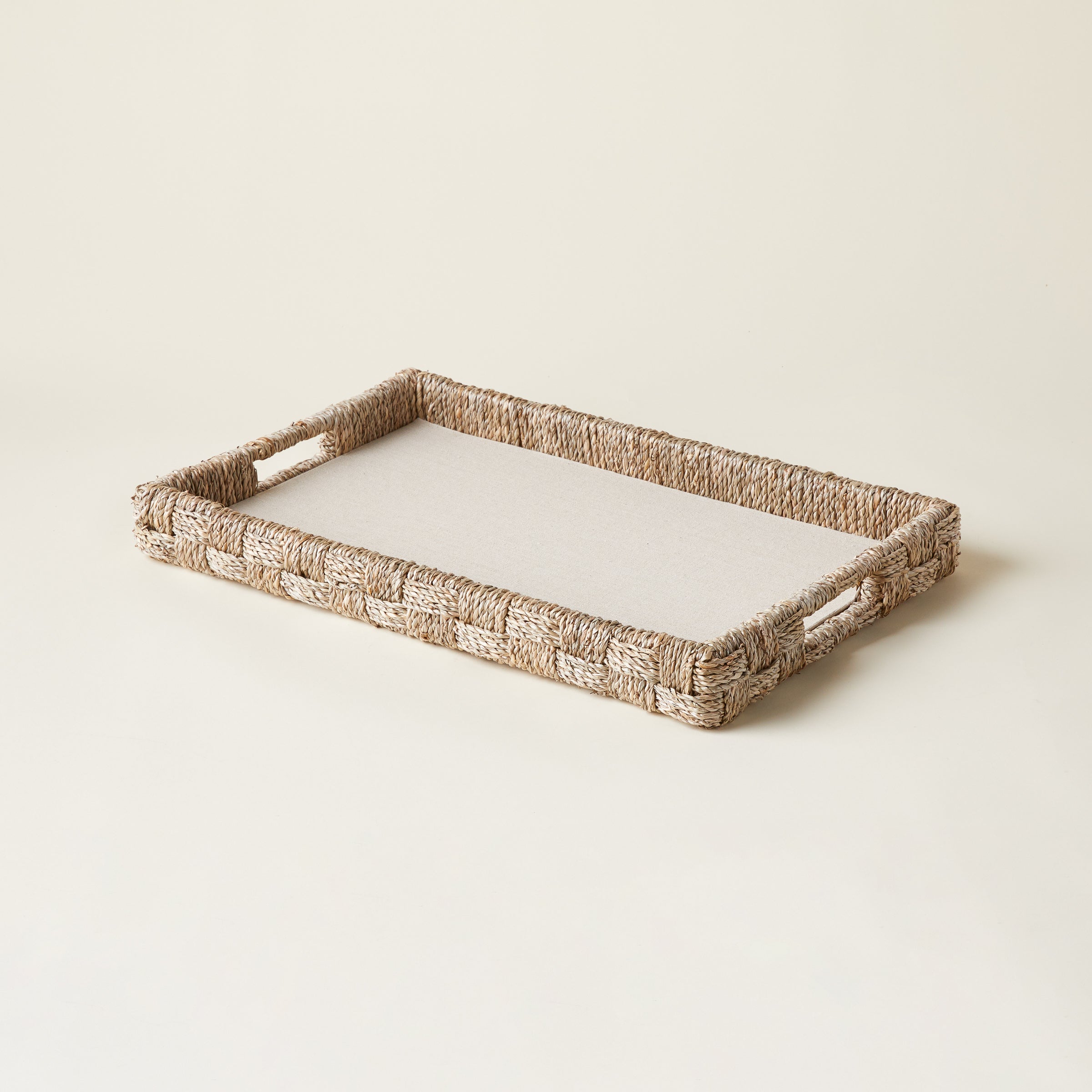 Woven seagrass and rattan serving tray with a natural finish.