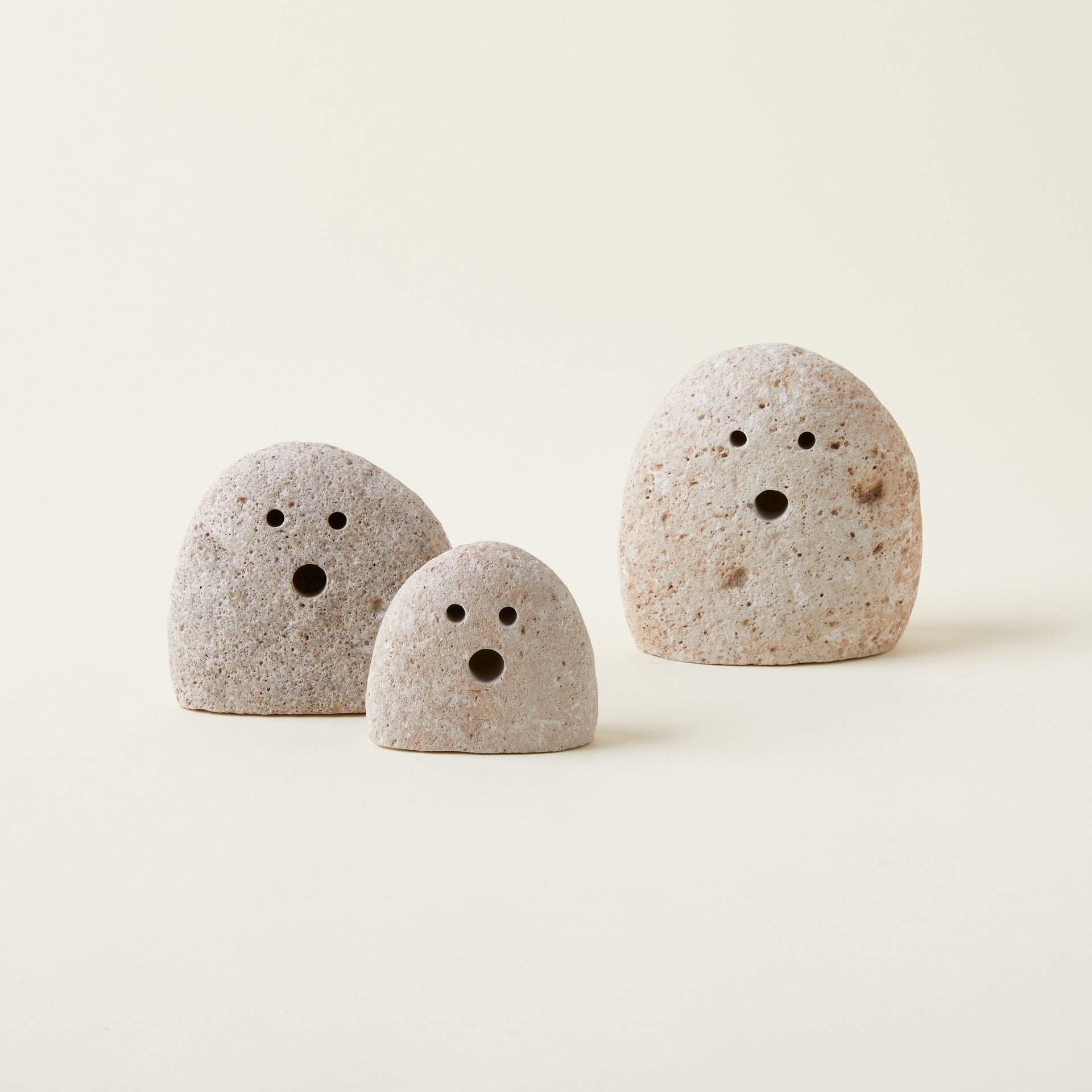 Set of three handcrafted river rock ghosts in varying sizes for whimsical fall decor.