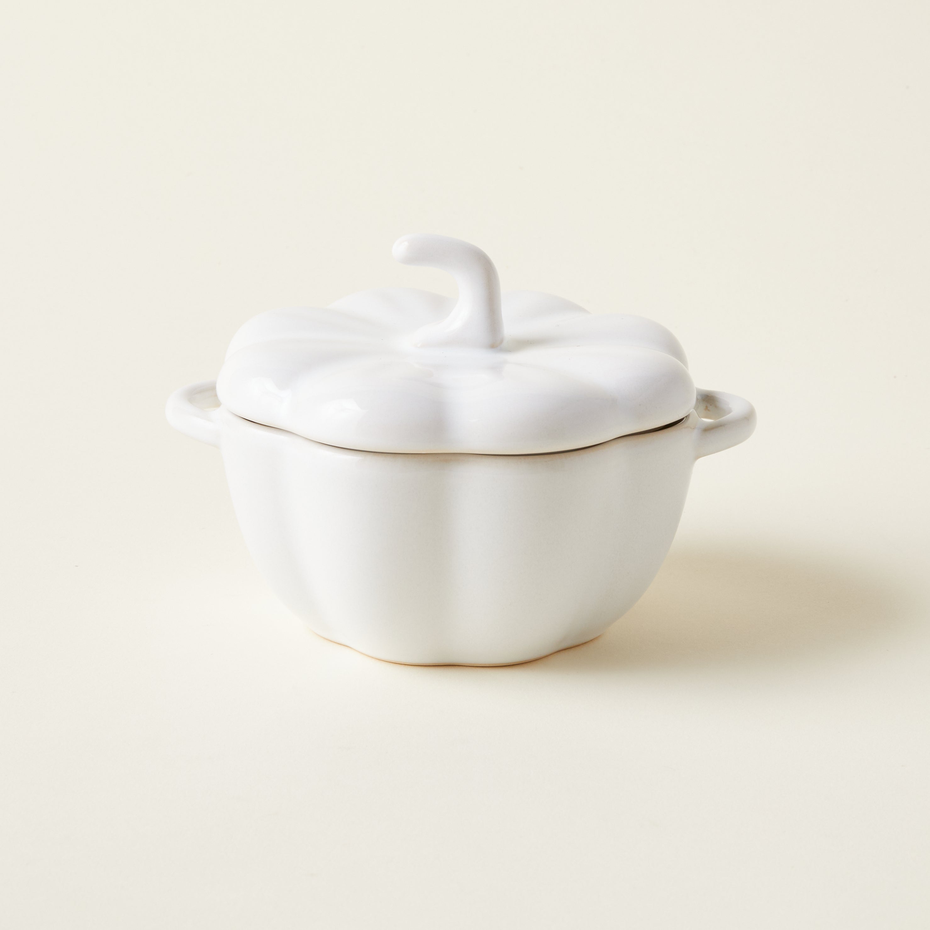 A handcrafted stoneware pumpkin baker with a sculptural design and convenient handles.