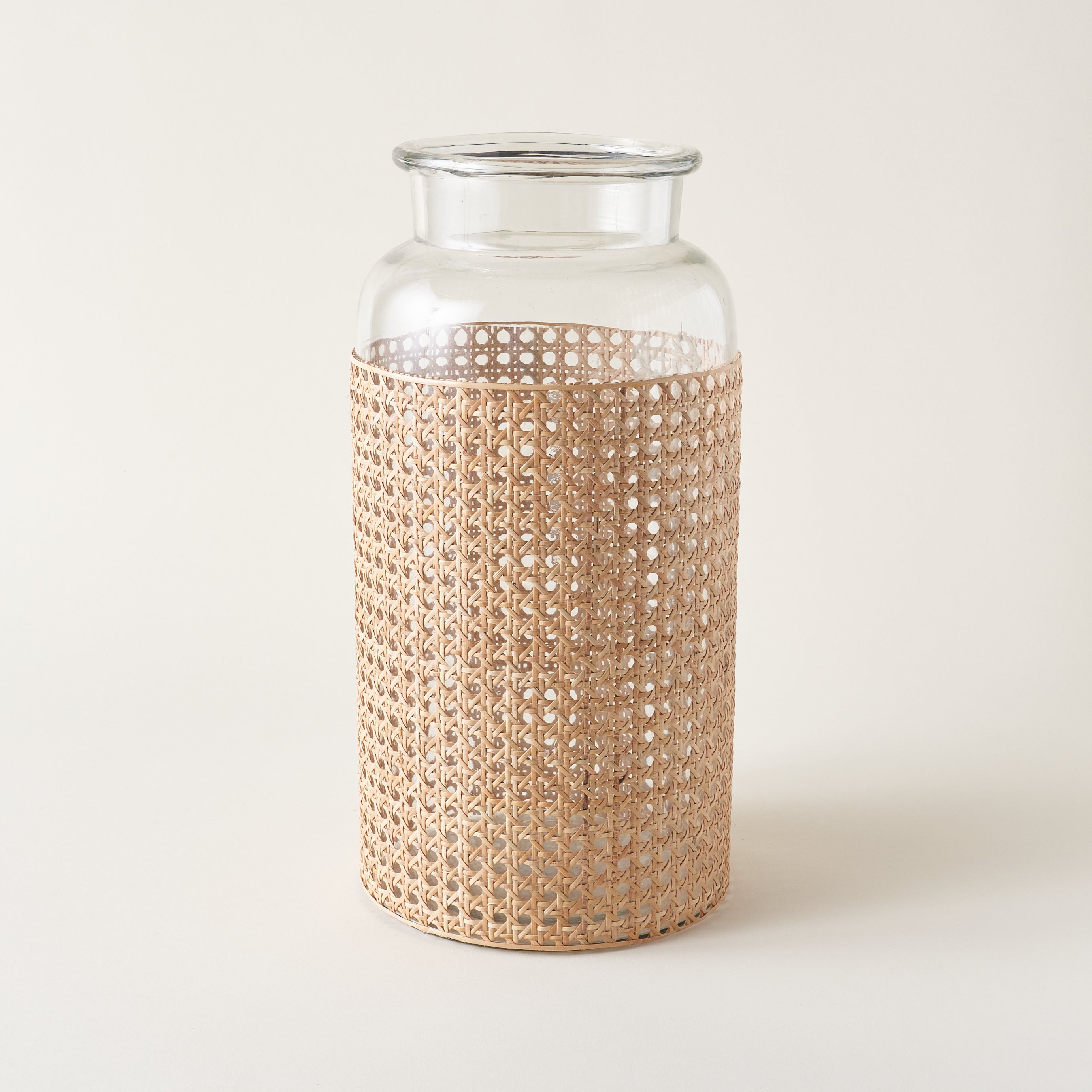 Clear glass vase with a woven cane covering.