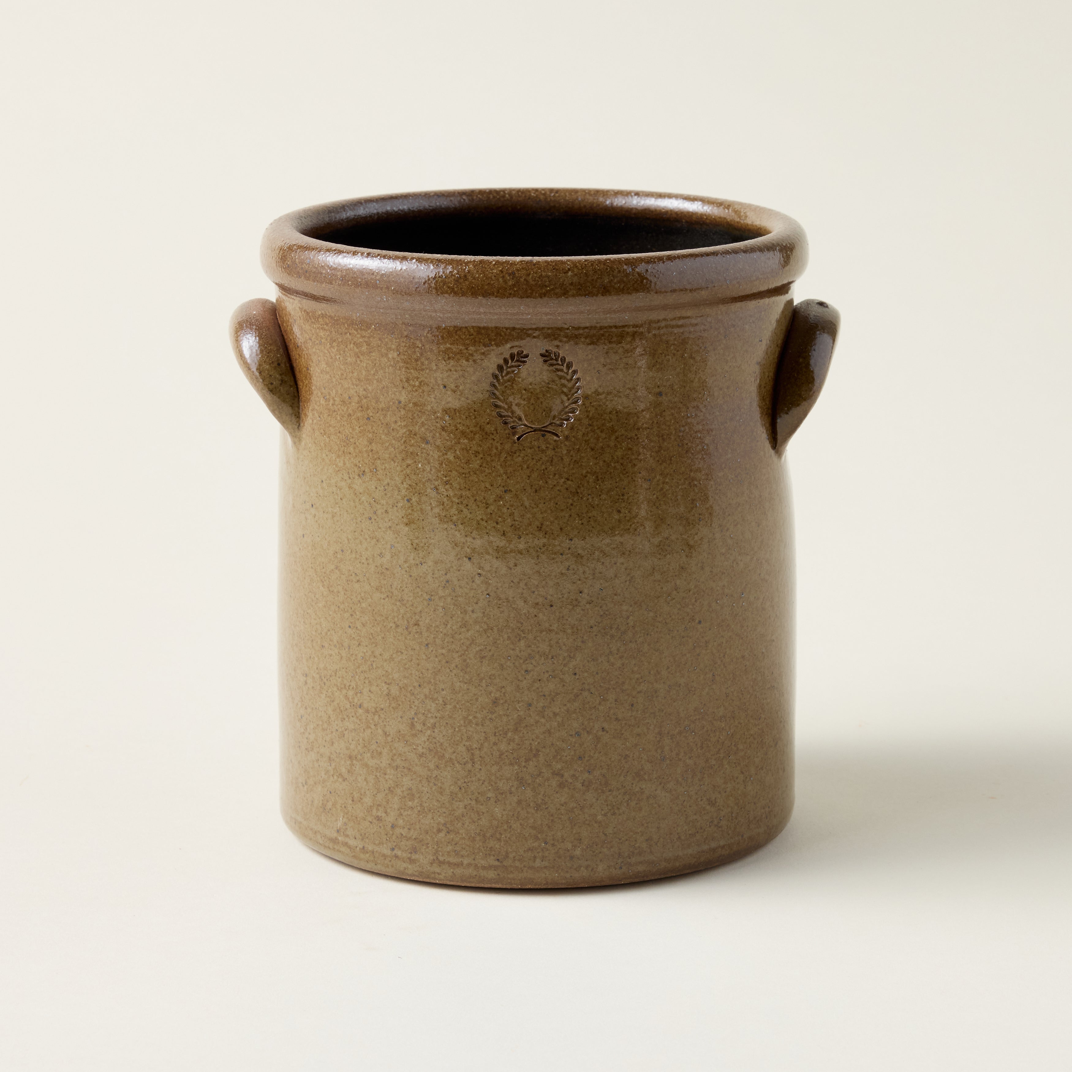 Handcrafted agrarian crock with a warm earthy brown exterior, natural iron flecking, and a hand-stamped handle.