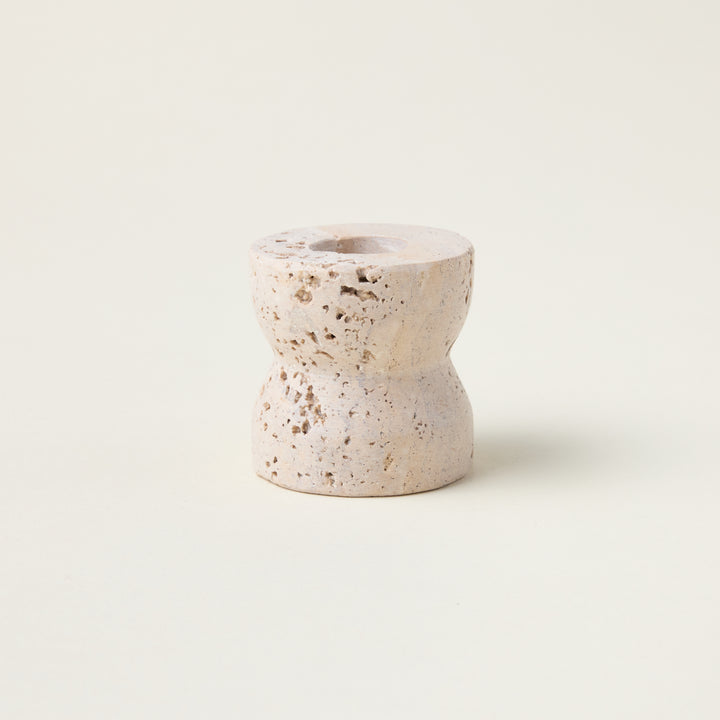 Sculptural taper candle holder crafted from genuine travertine marble with a smooth, refined finish.