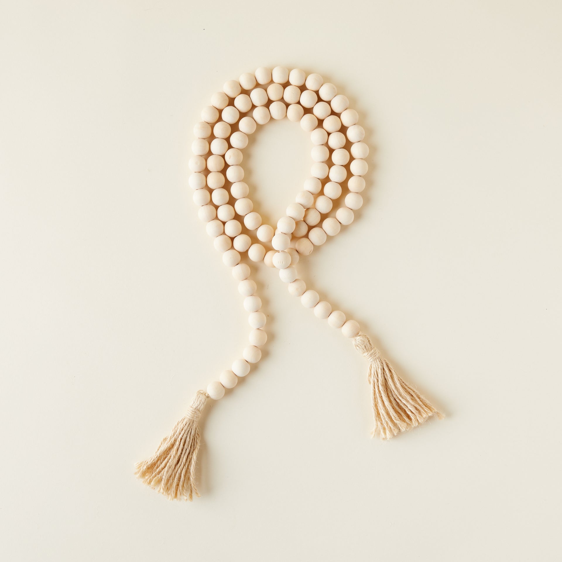 A strand of natural wood beads with a tassel on one end.
