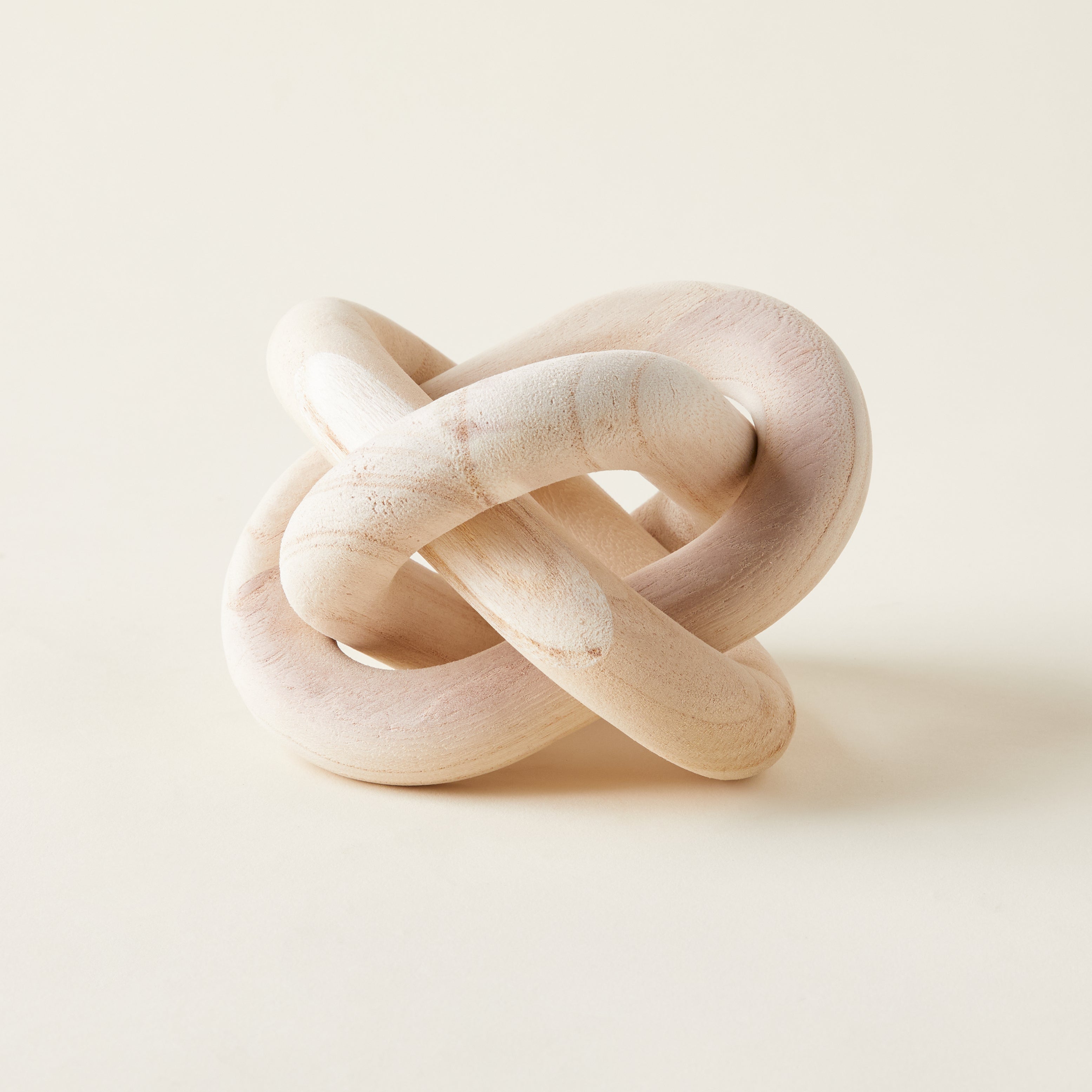 A decorative chain of interlocking wooden links carved from rustic pine.